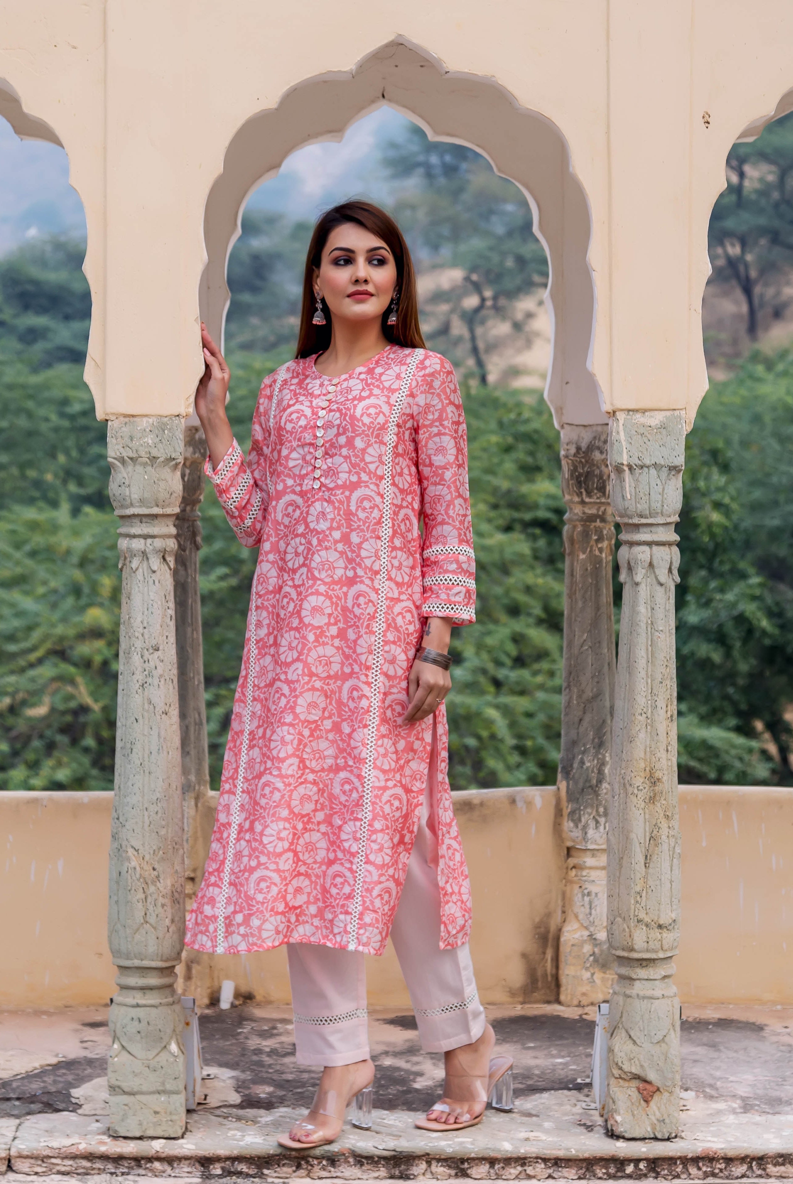 Model wearing a peach kurta with white floral hand block print and lace details.