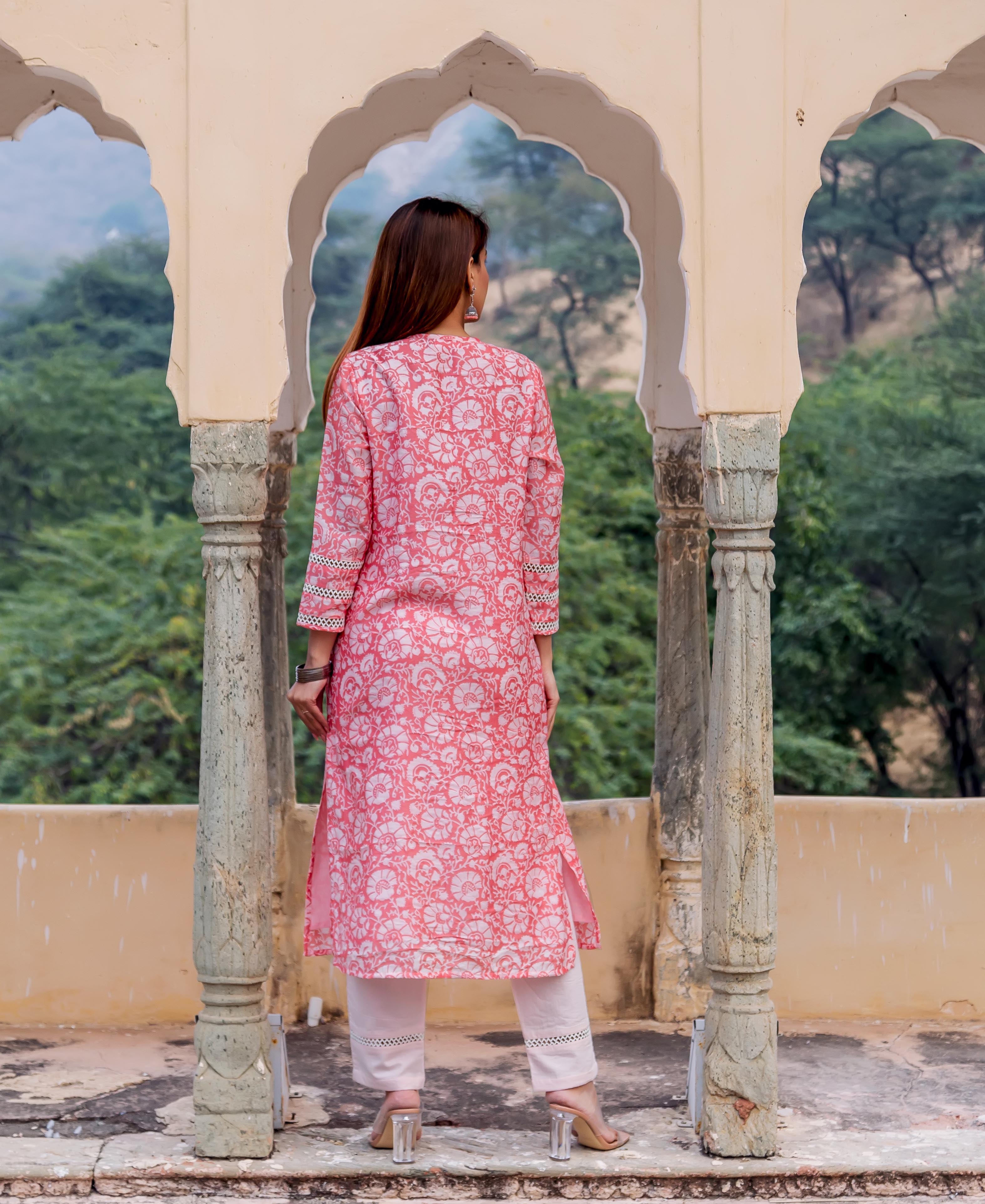 Back view of woman wearing a peach hand block printed kurta with white floral patterns.