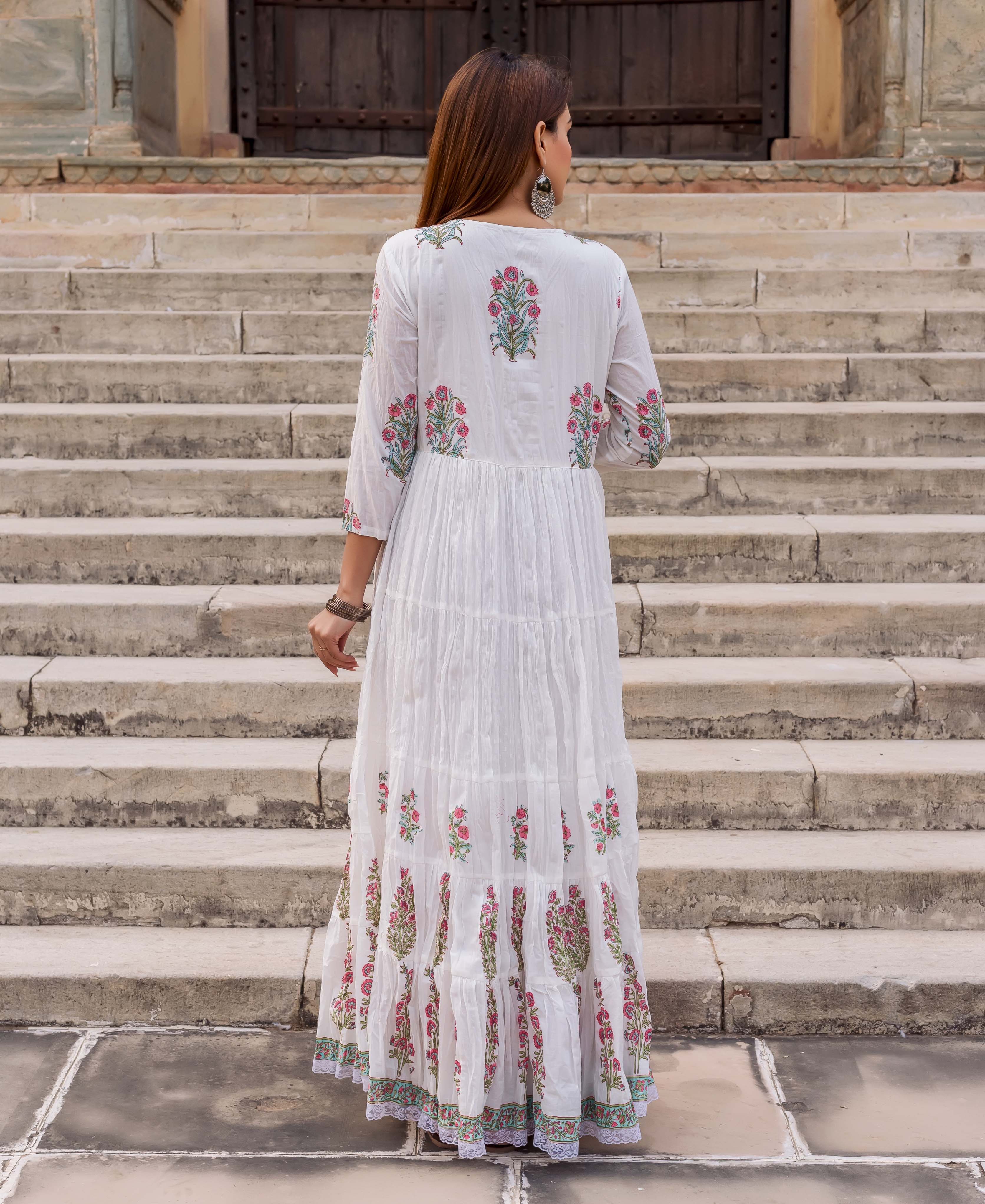 Back view of model in a white tiered dress with pink and green floral butta print.