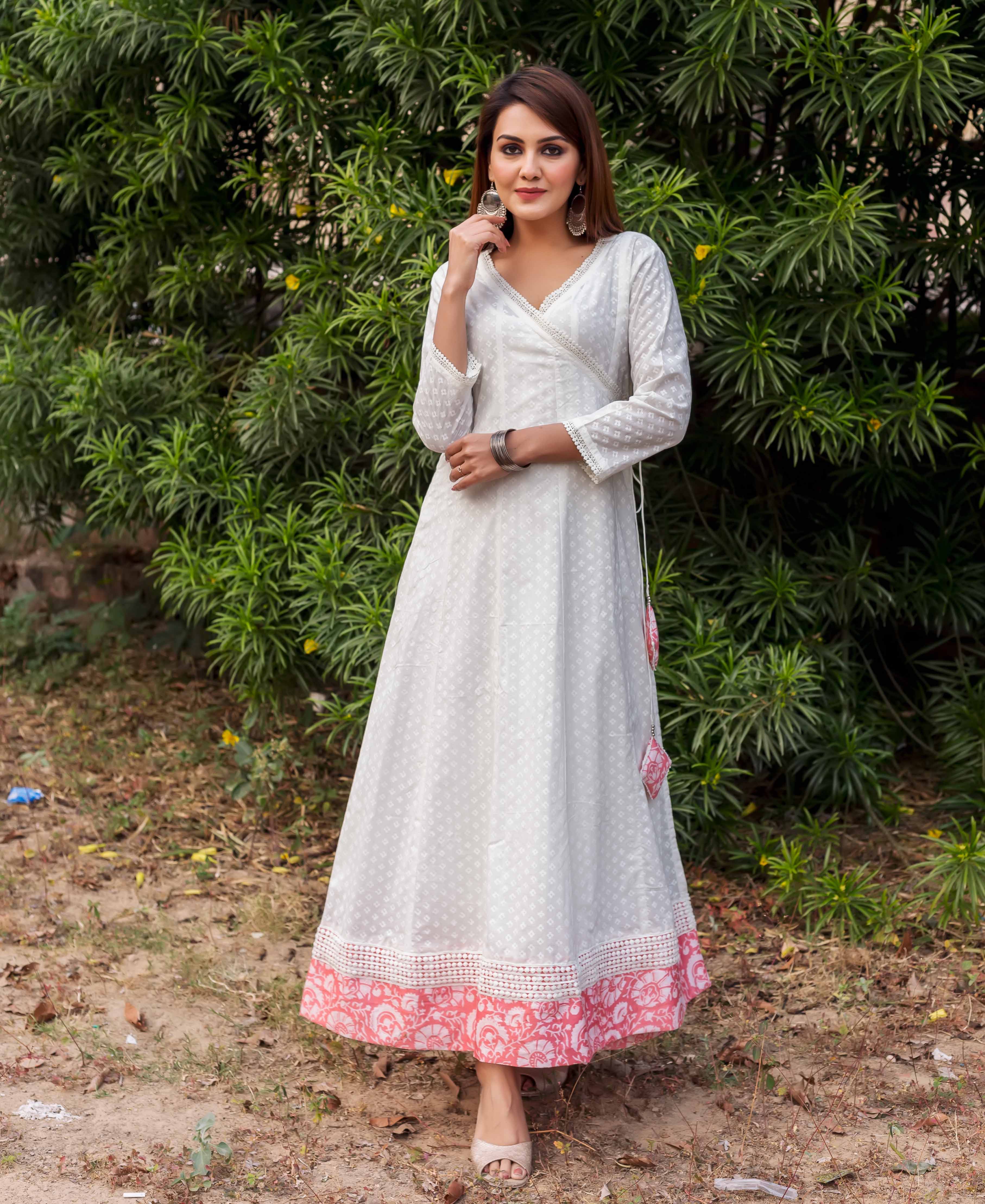 Full-length white angrakha dress with subtle pattern and peach hand-block-printed hem on model.