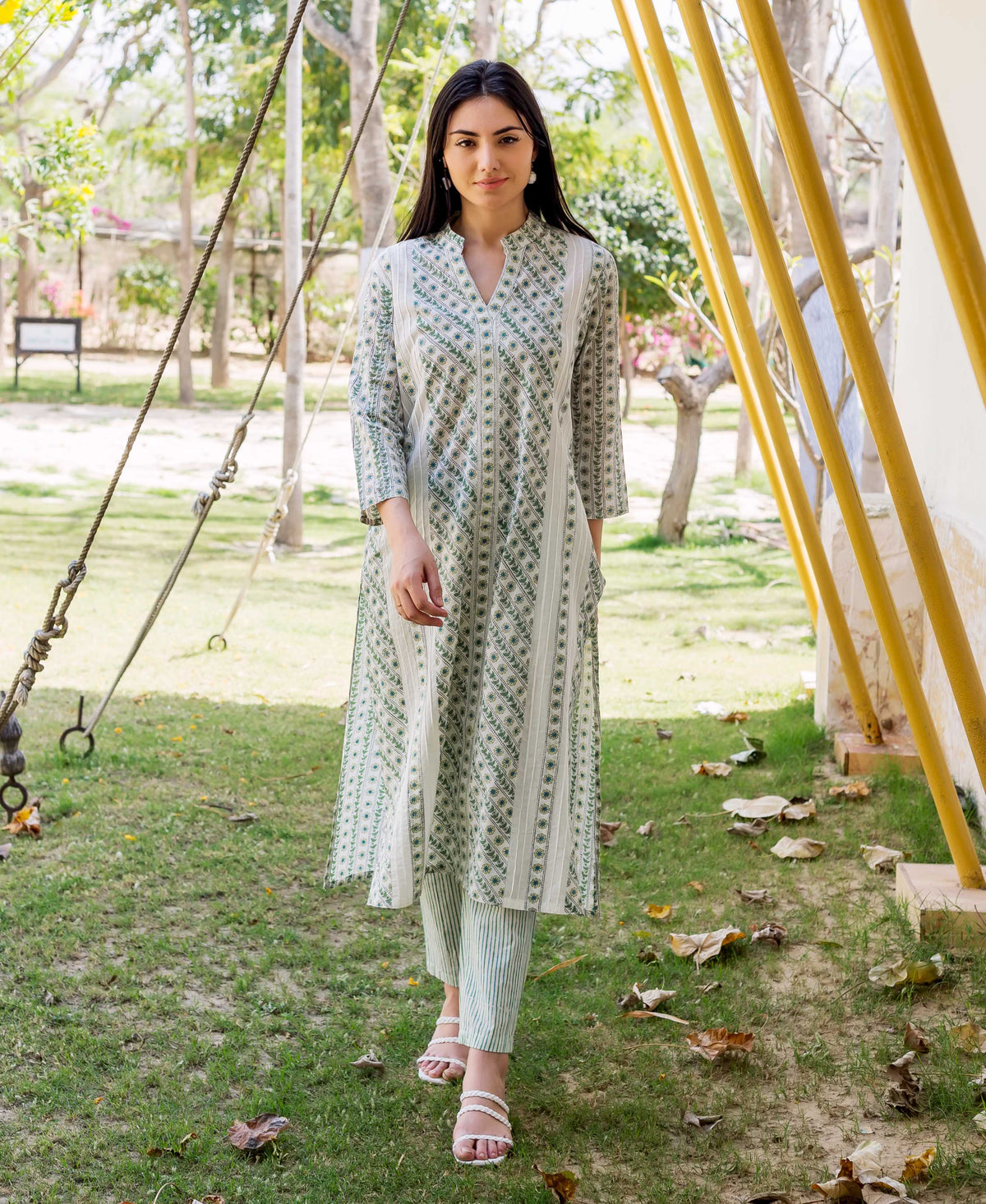 A model wearing a white and green hand-block-printed kurta with a V-neck and three-quarter sleeves.