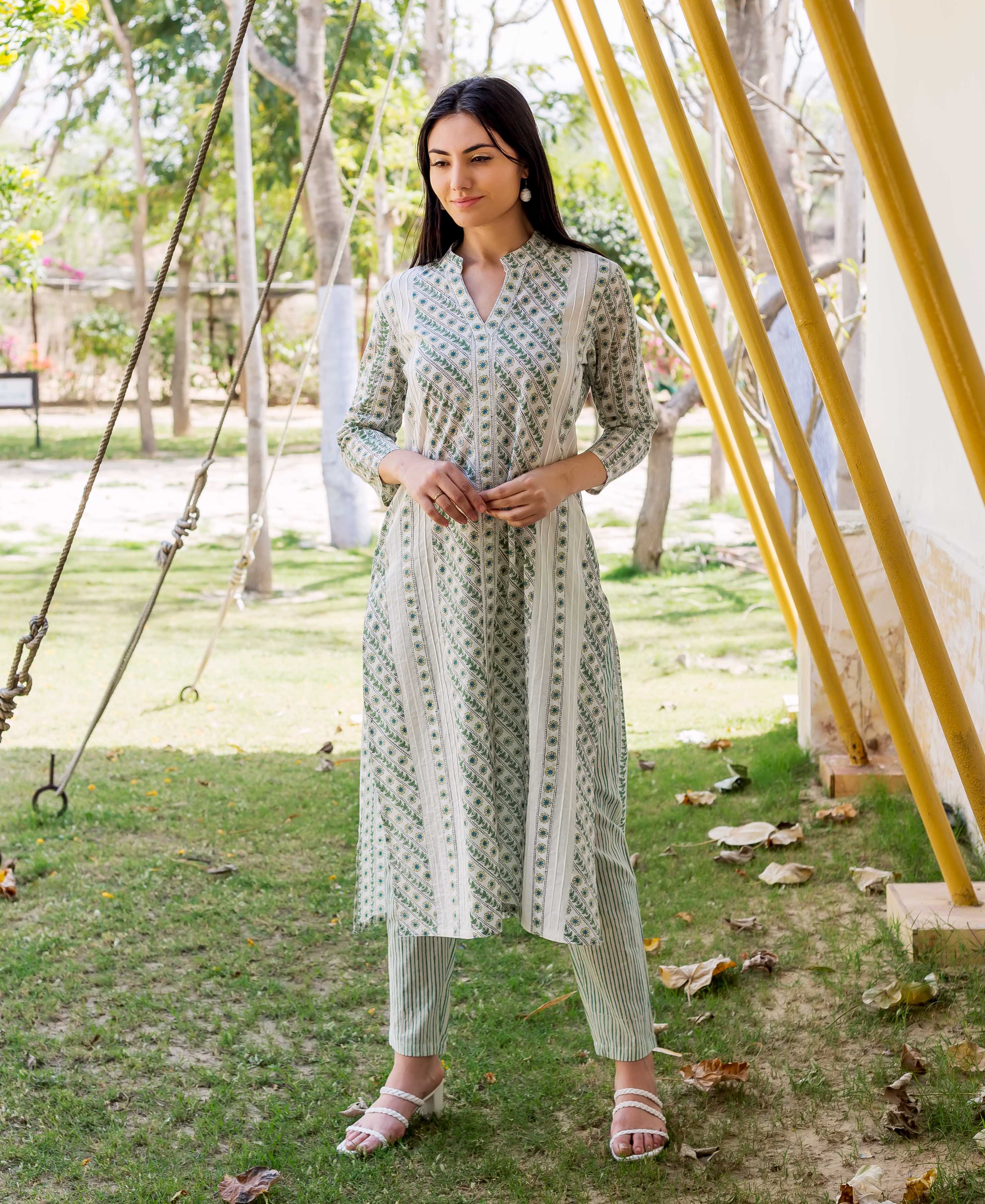 A model wearing a white and green hand-block-printed kurta with a floral pattern.