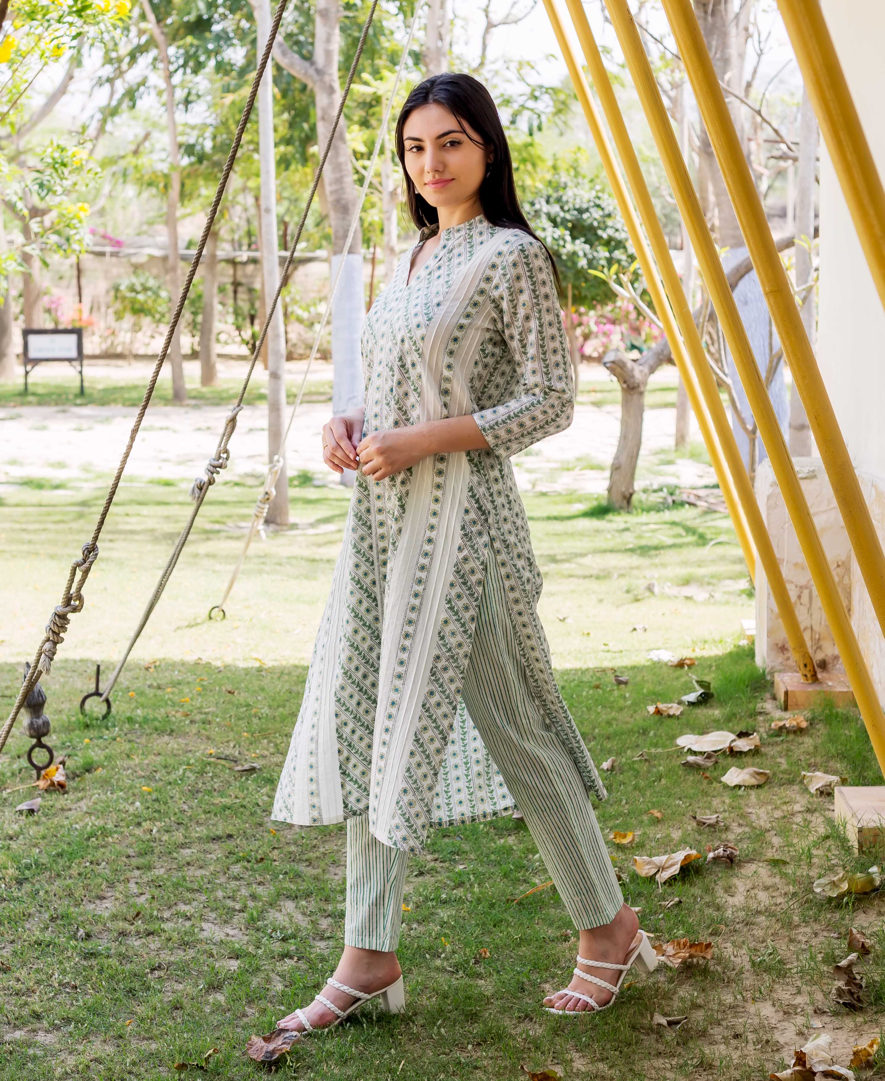 A woman in a white and green hand-block-printed kurta with a matching dupatta.