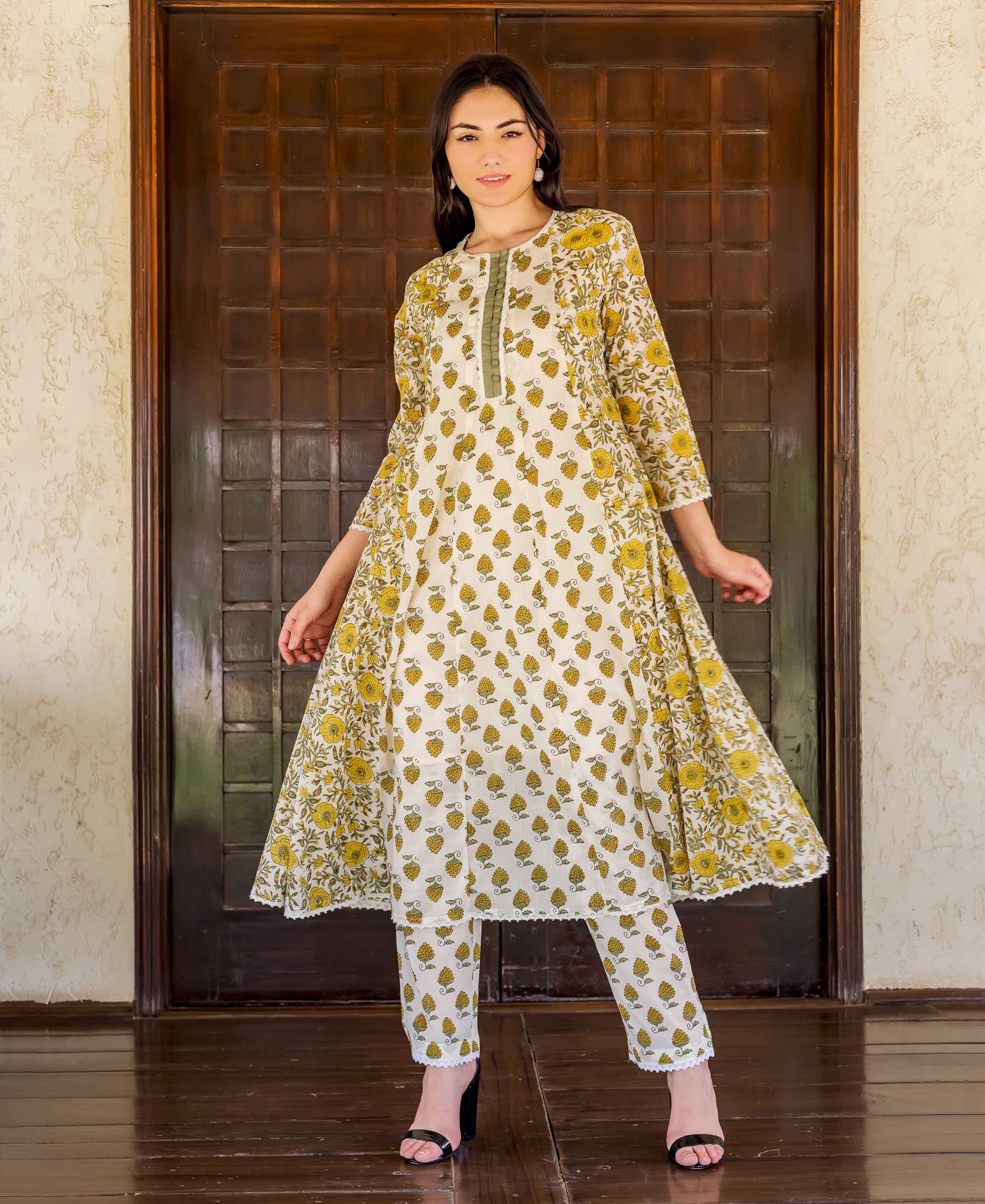White and ochre hand block printed A-line kurta set with floral print on model.