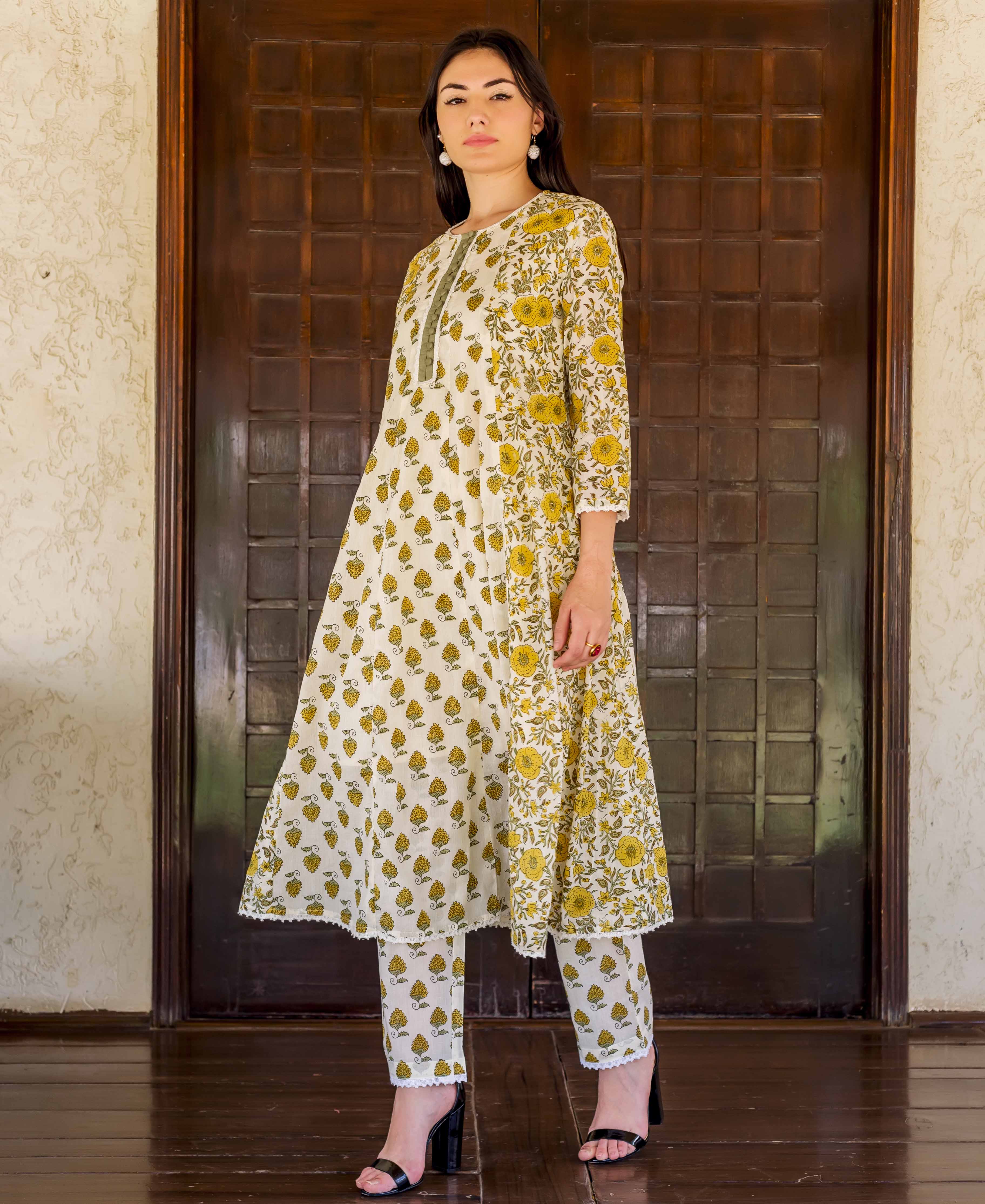 Model in a white and ochre hand block printed A-line kurta and matching pants.