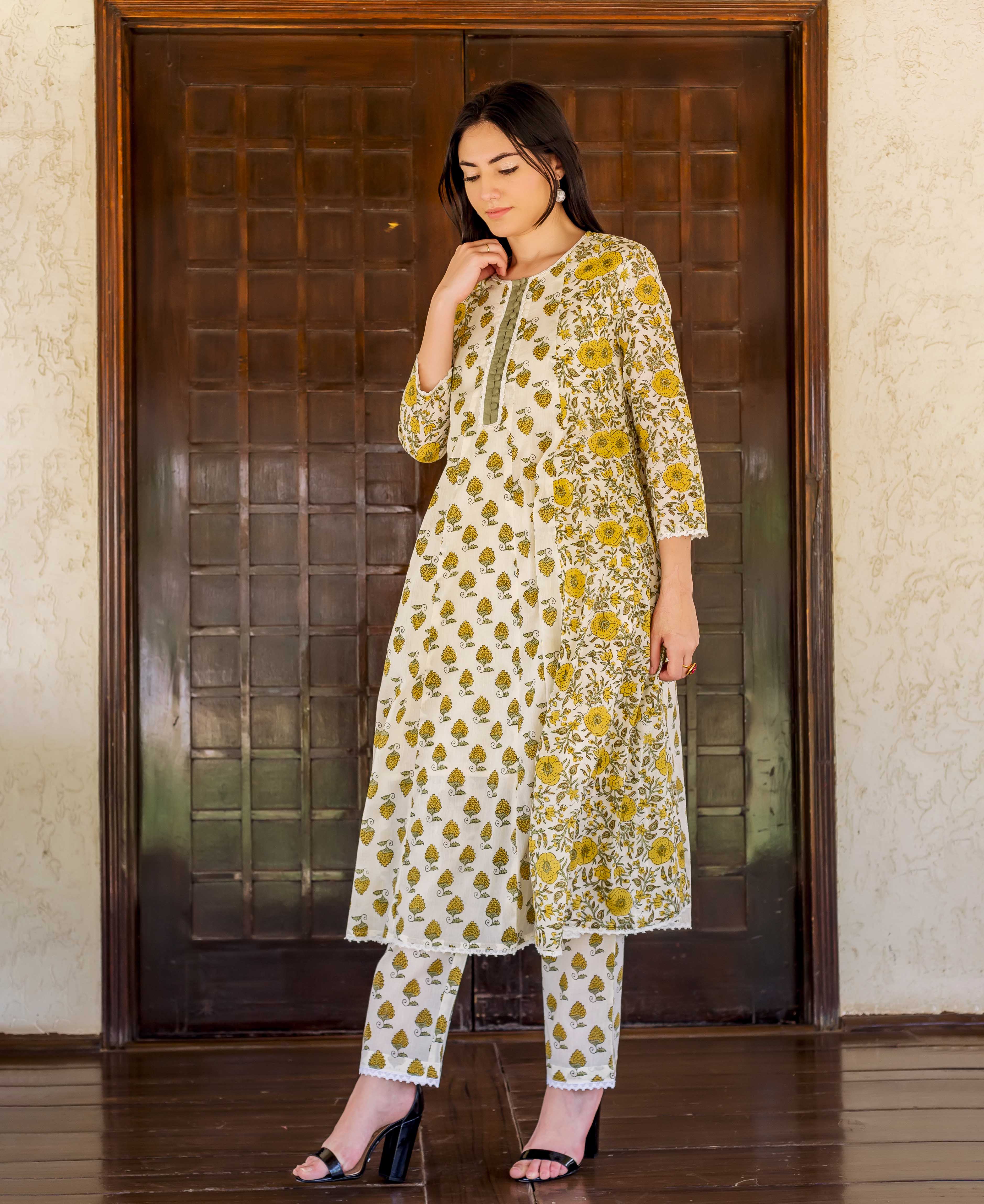 White and yellow hand block printed A-line kurta and pants on a female model.