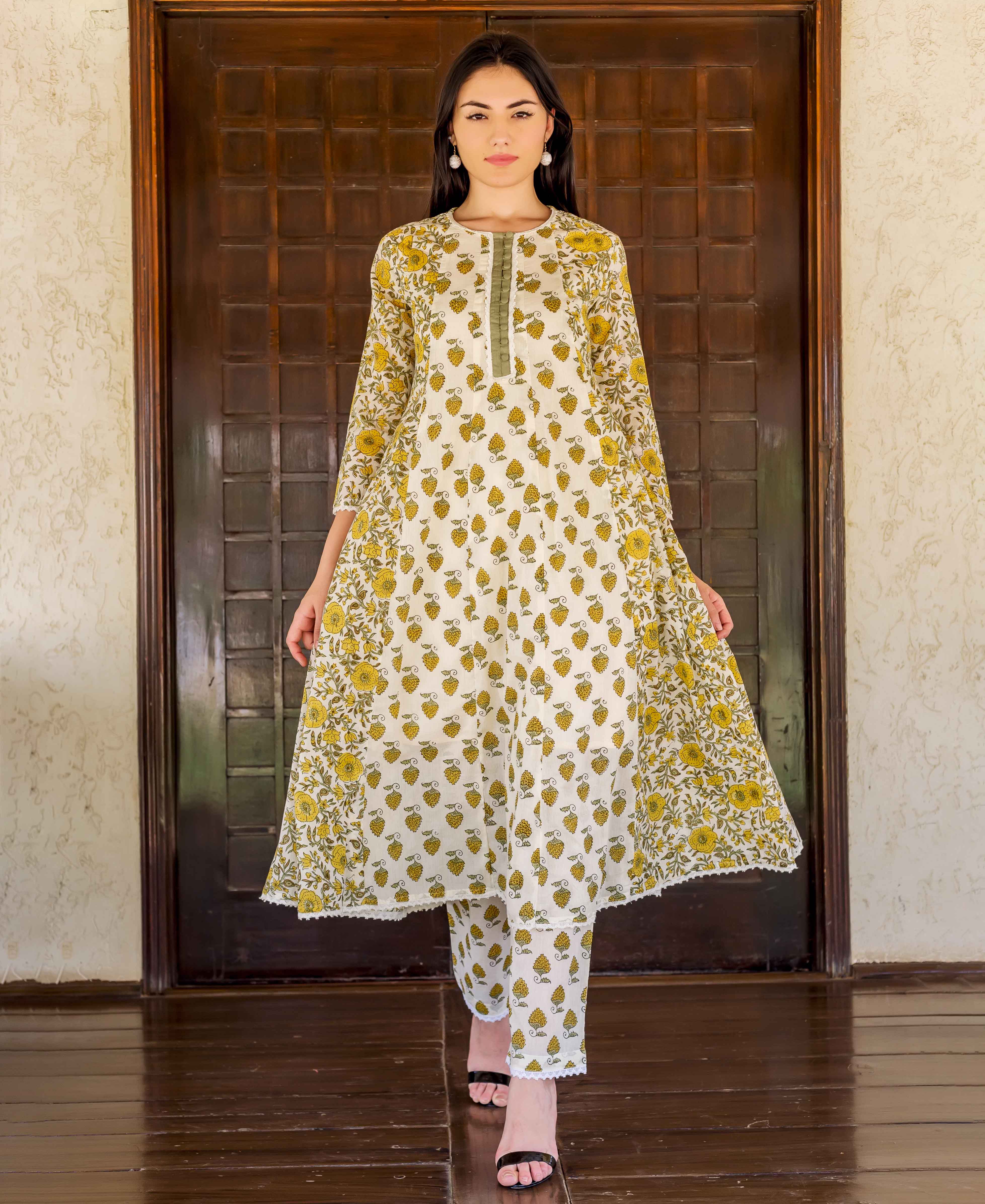 Full-length shot: model wearing a white and ochre floral hand block printed A-line kurta set.