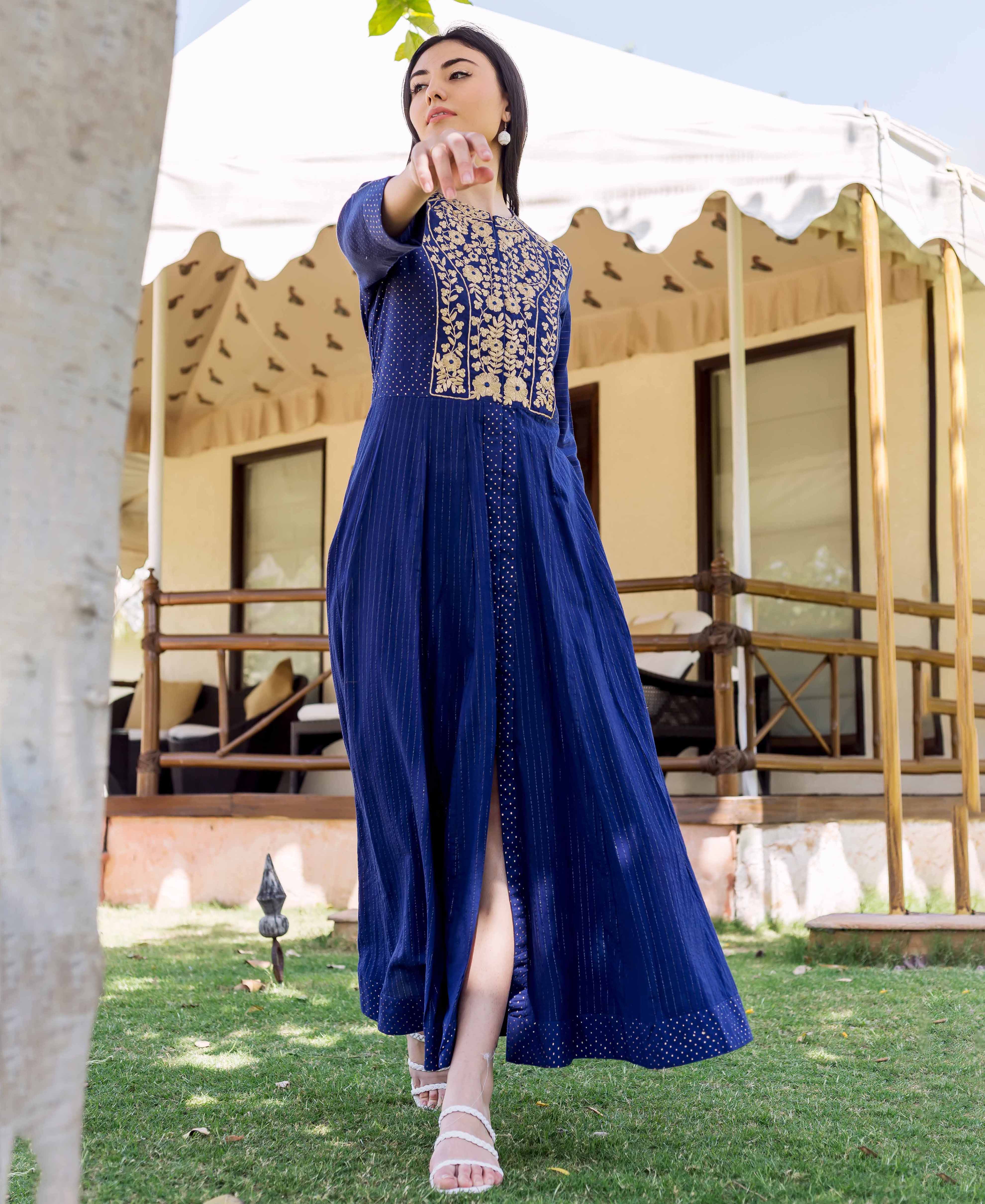 Model wearing a royal blue dress with gold embroidery and subtle stripe and dot prints.