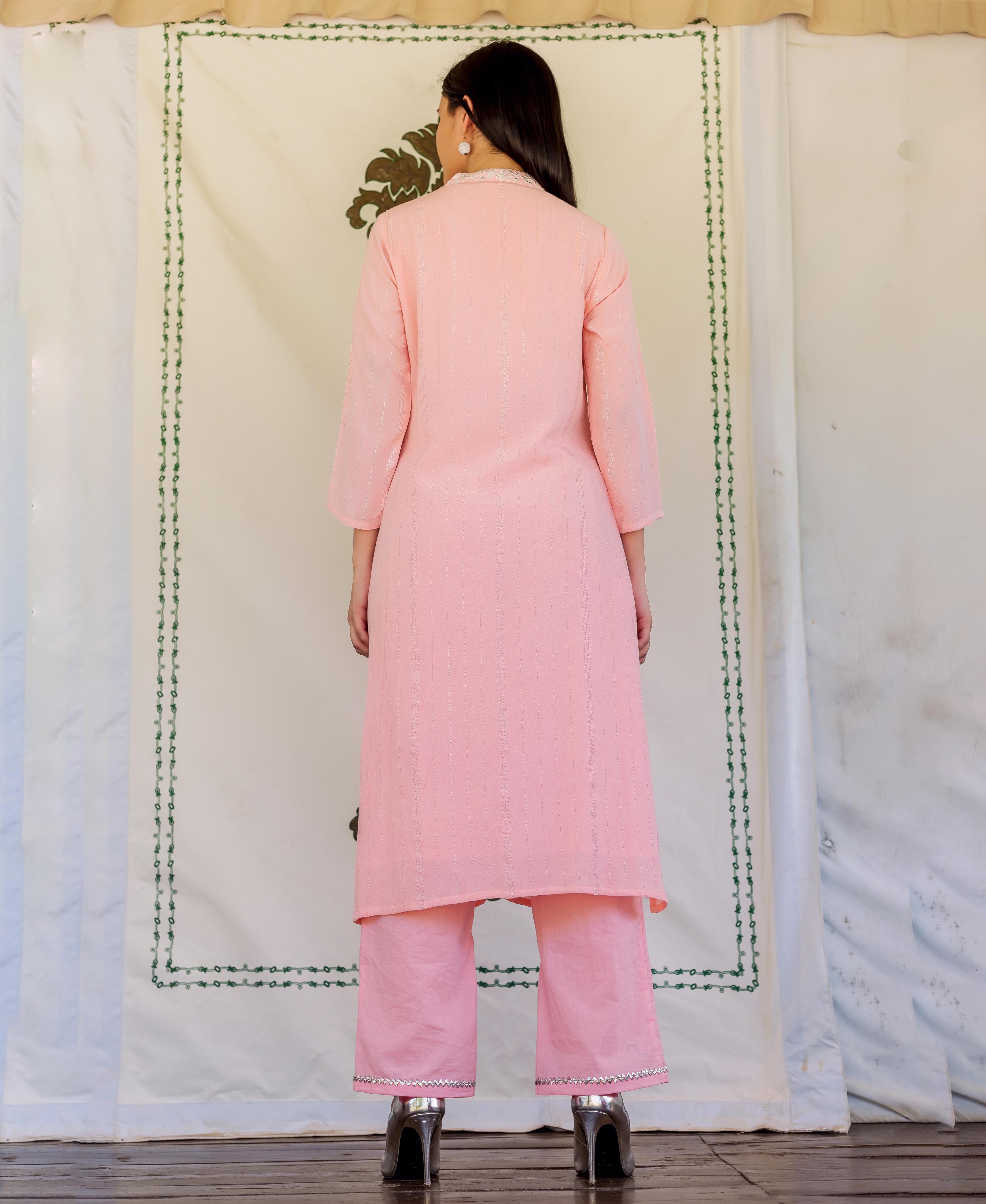 Back view of model in pink straight kurta with subtle stripes and embroidered pants.