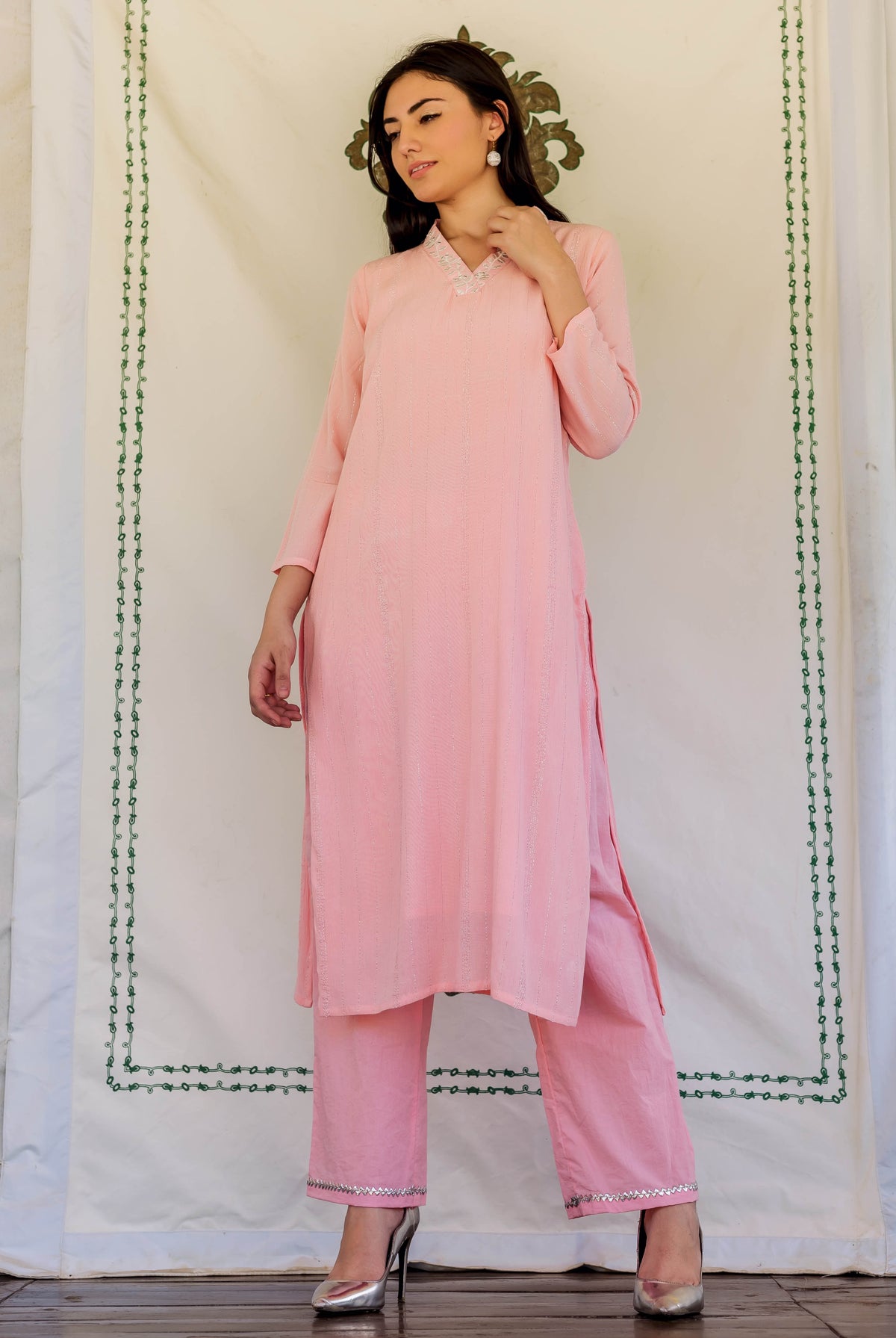 Front view of model in pink straight kurta and matching pants with embroidered neckline.