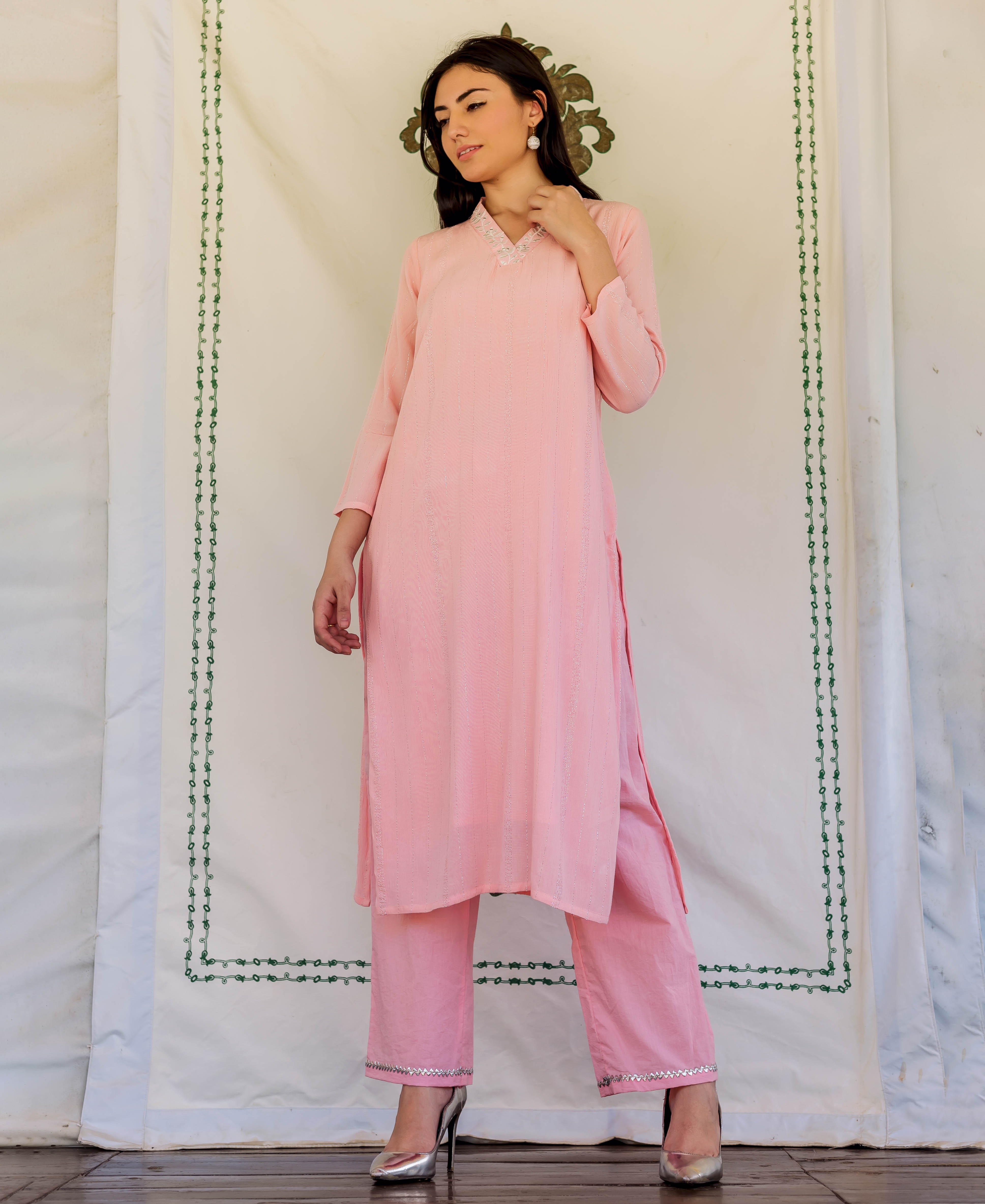 Front view of model in pink straight kurta and matching pants with embroidered neckline.