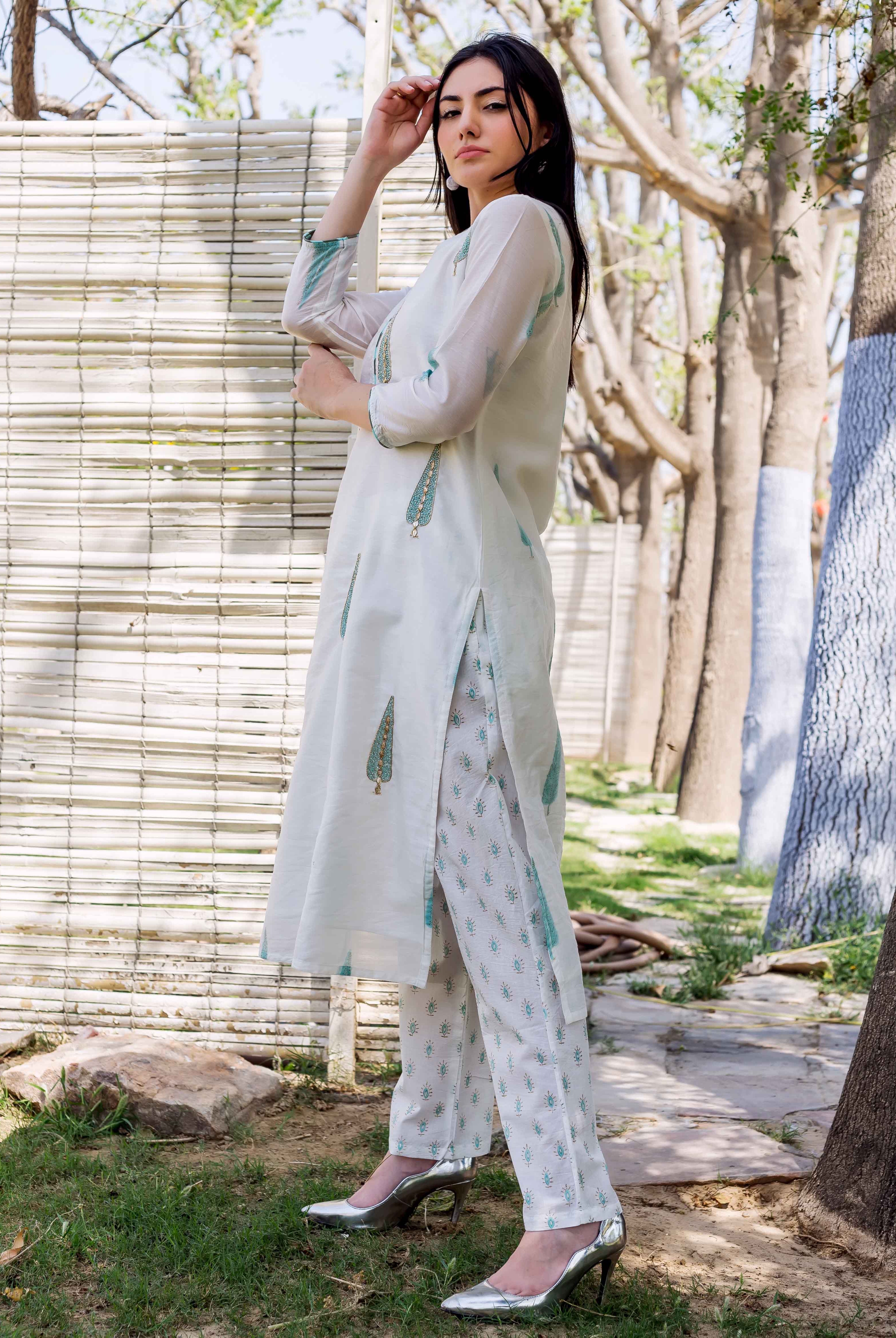 Side view of a model wearing a white hand block printed straight kurta with matching ethnic pants.