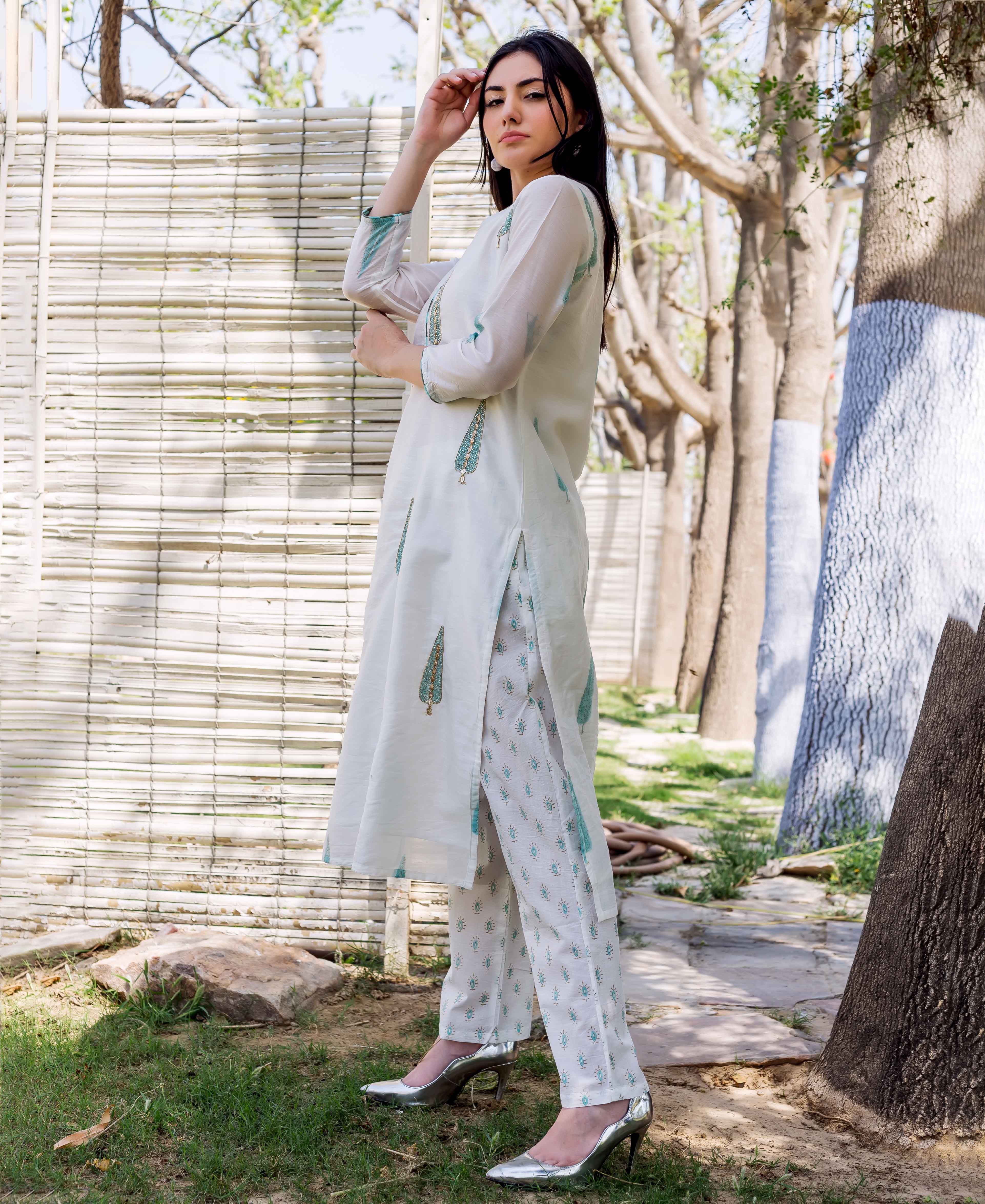 Side view of a model wearing a white hand block printed straight kurta with matching ethnic pants.