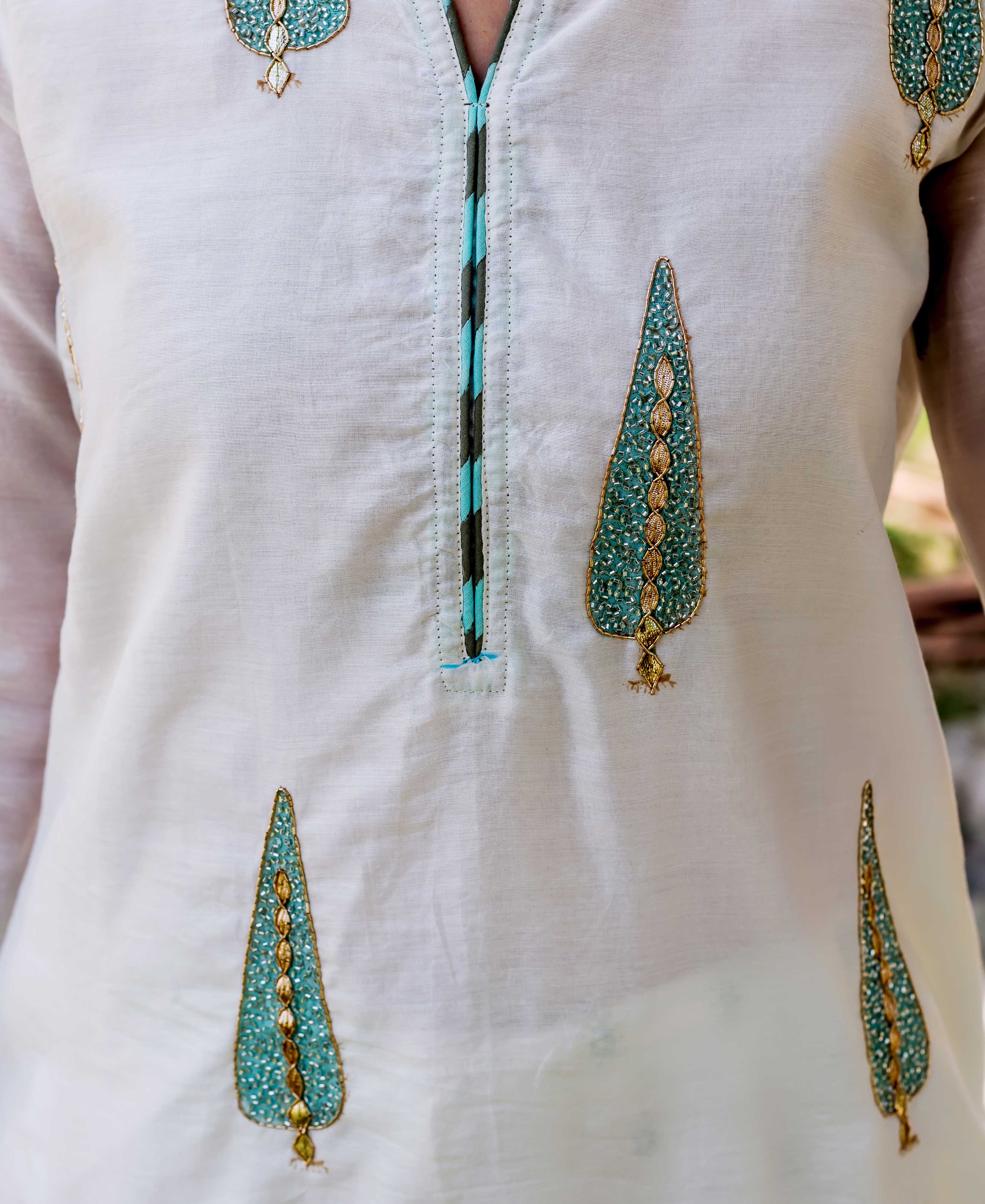 Light grey kurta featuring teal and gold embroidered leaf patterns and a chevron-trimmed placket.