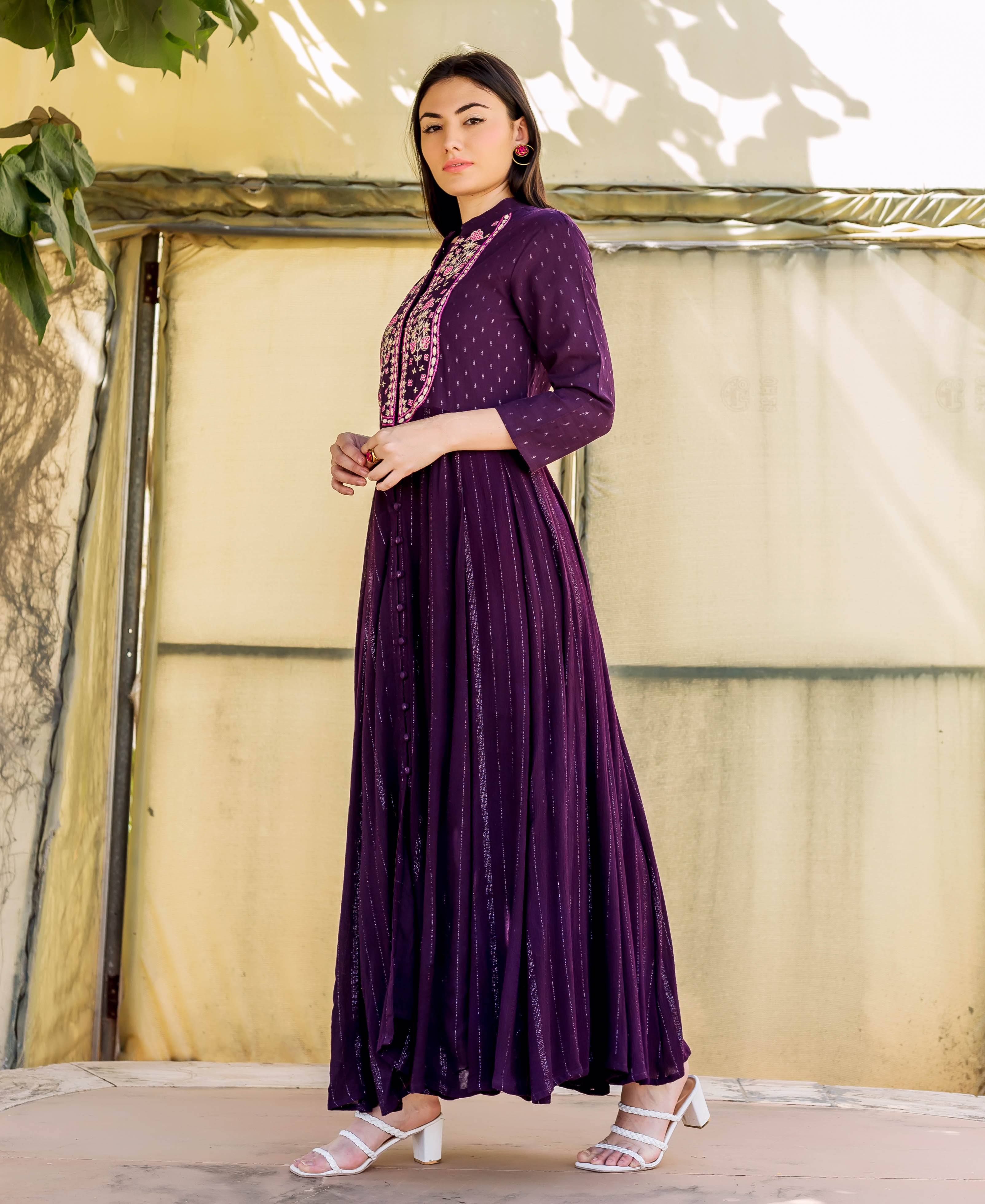 Model in a full-length wine Anarkali dress with intricate embroidery and lurex striped pattern.
