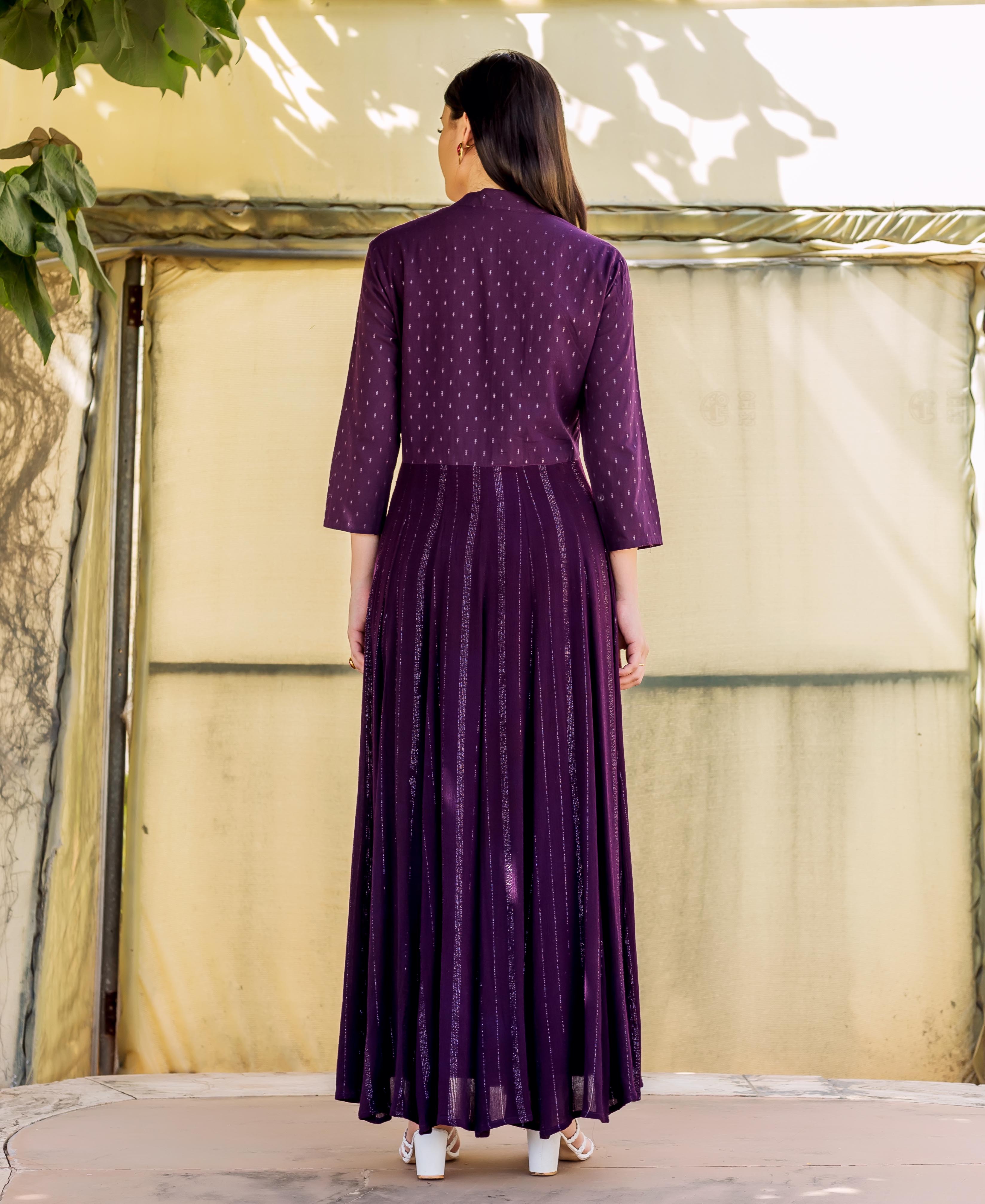 Back view of model in a deep purple Anarkali with dotted embroidery and lurex-striped skirt.