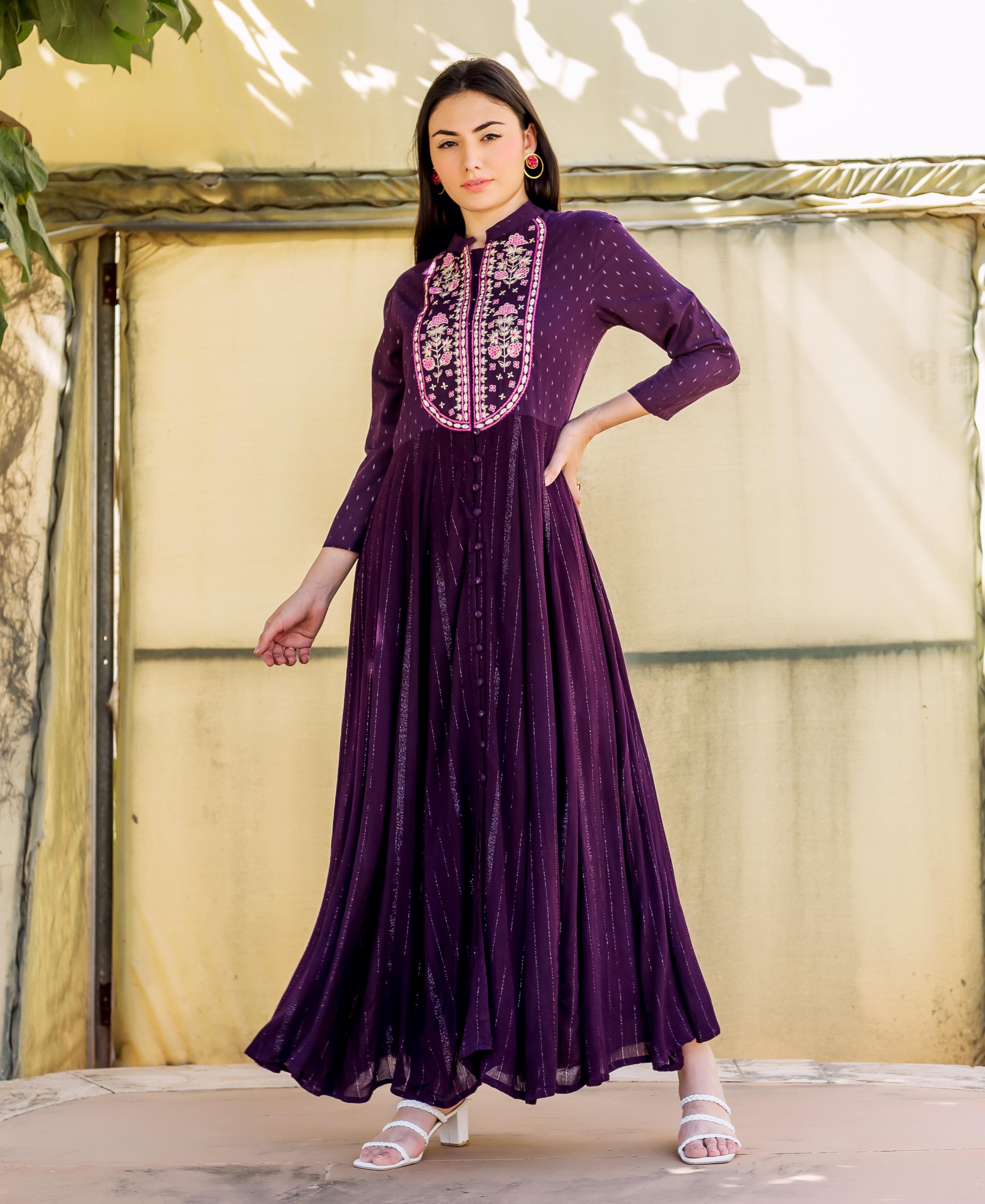 Model wearing a full-length wine lurex Anarkali dress with intricate embroidered yoke.