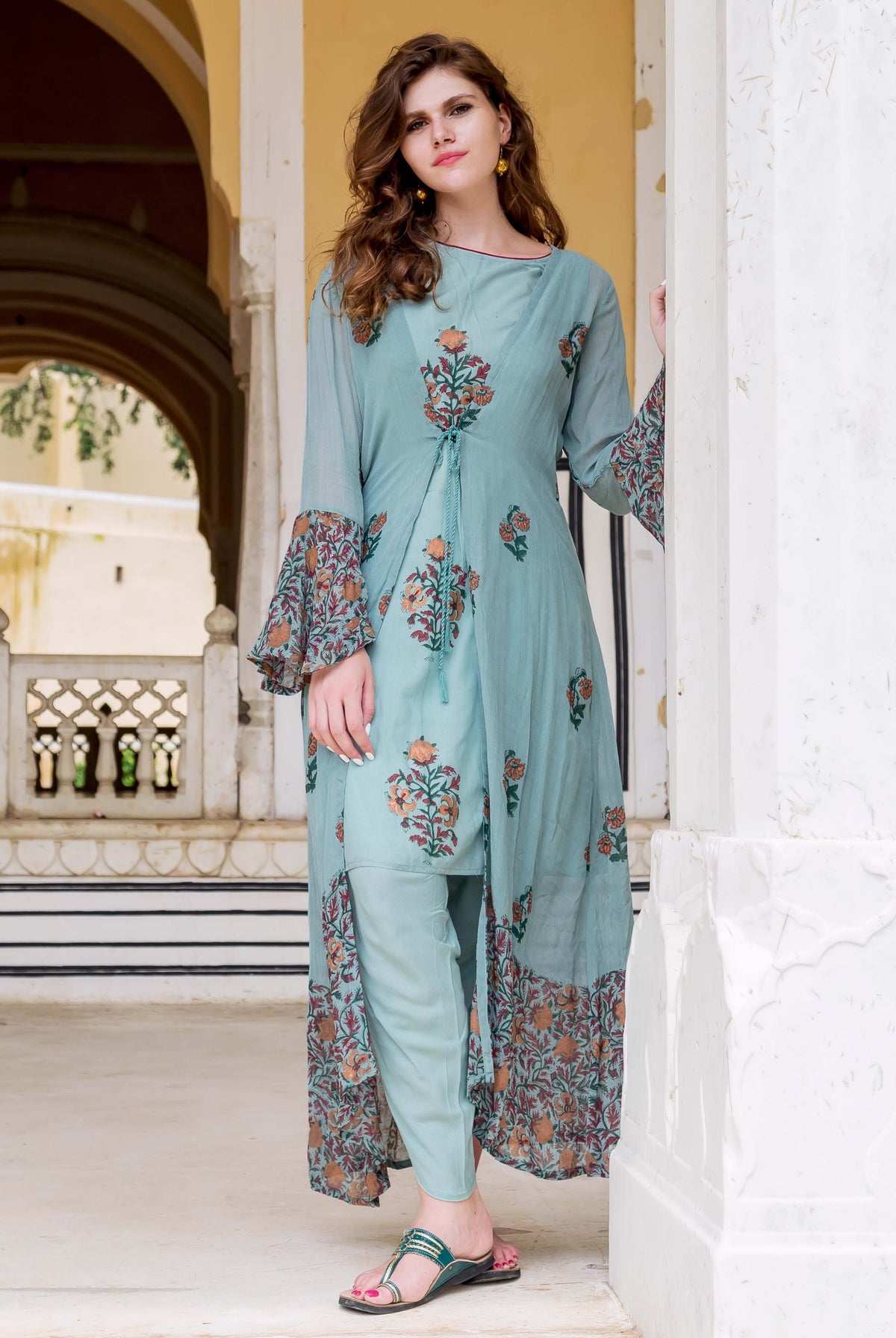Model wearing Turkish blue hand-block printed dhoti set with long floral jacket, front view.
