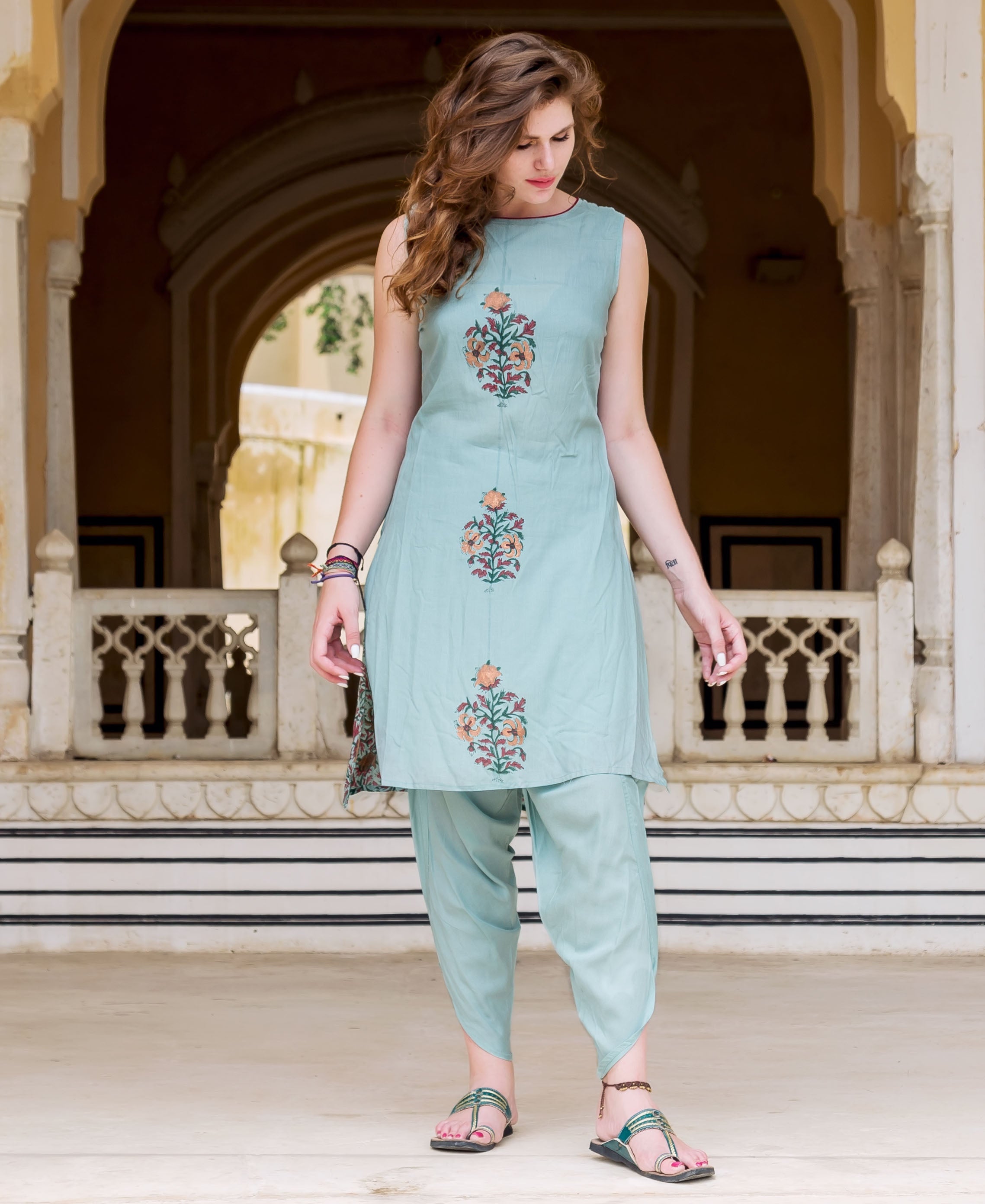 A woman in a light blue hand-block-printed dhoti set with floral designs.