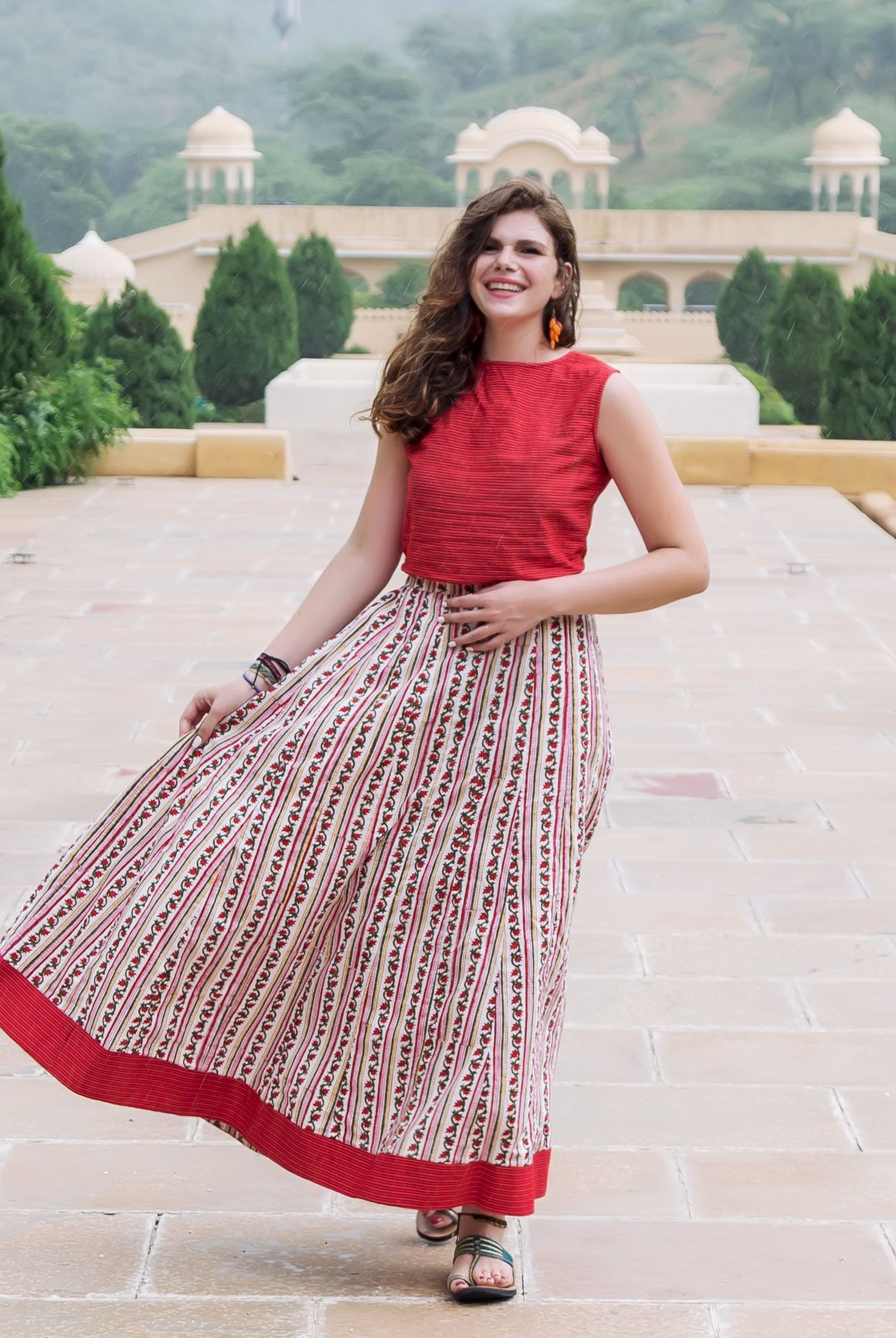 Smiling woman wearing red crop top with a red and white hand-block-printed skirt.