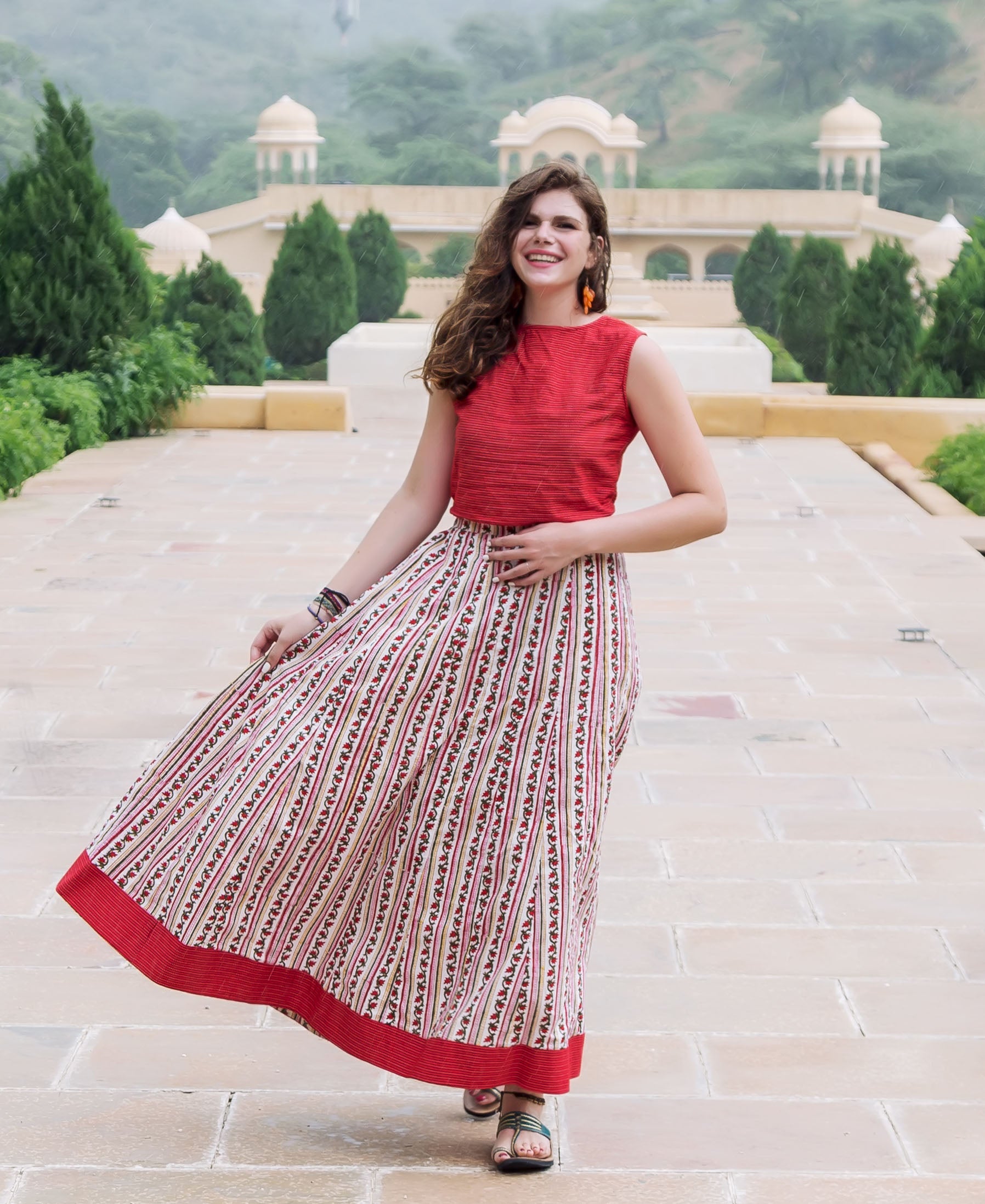 Smiling woman wearing red crop top with a red and white hand-block-printed skirt.