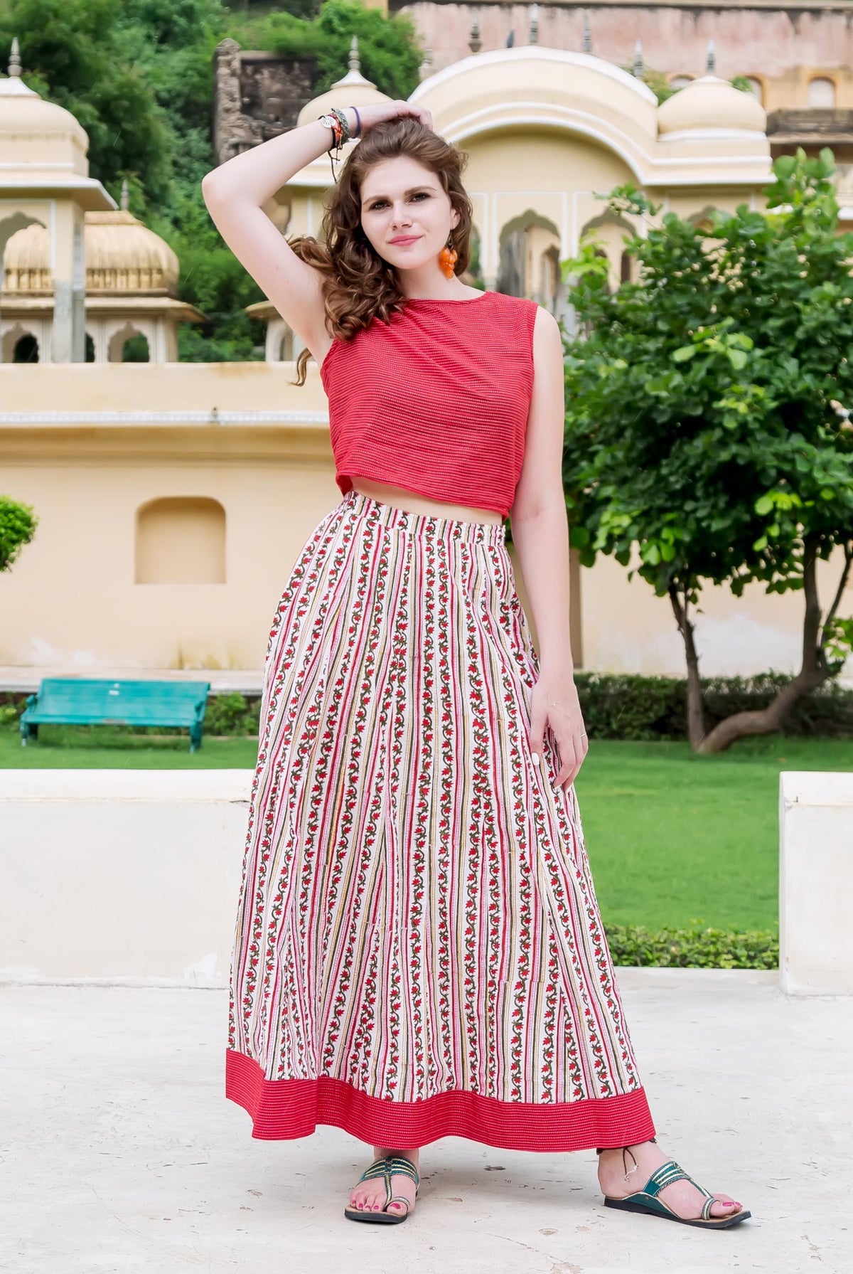 Model wears red crop top and white Missprint hand-block-printed floral striped maxi skirt.
