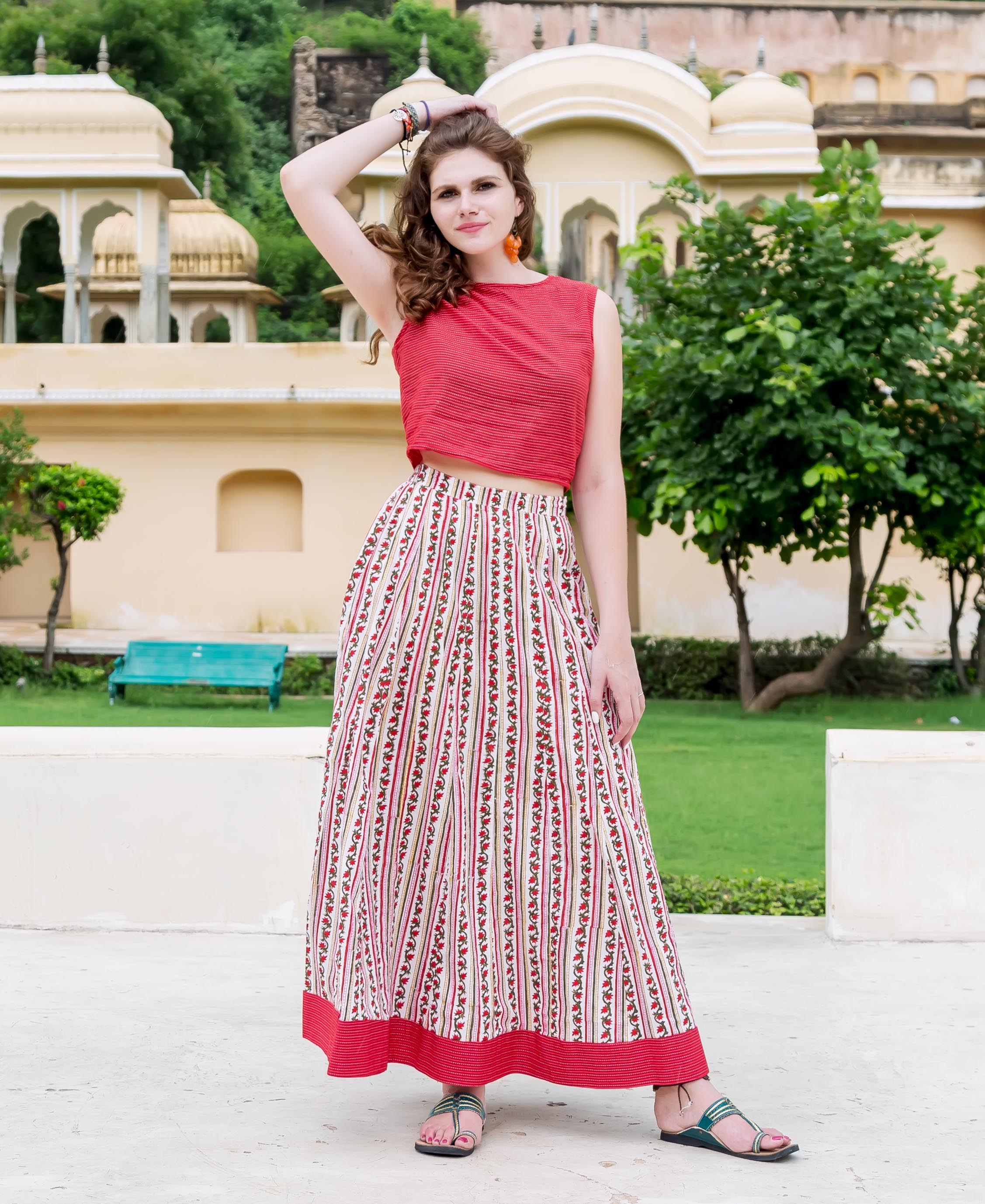 Model wears red crop top and white Missprint hand-block-printed floral striped maxi skirt.