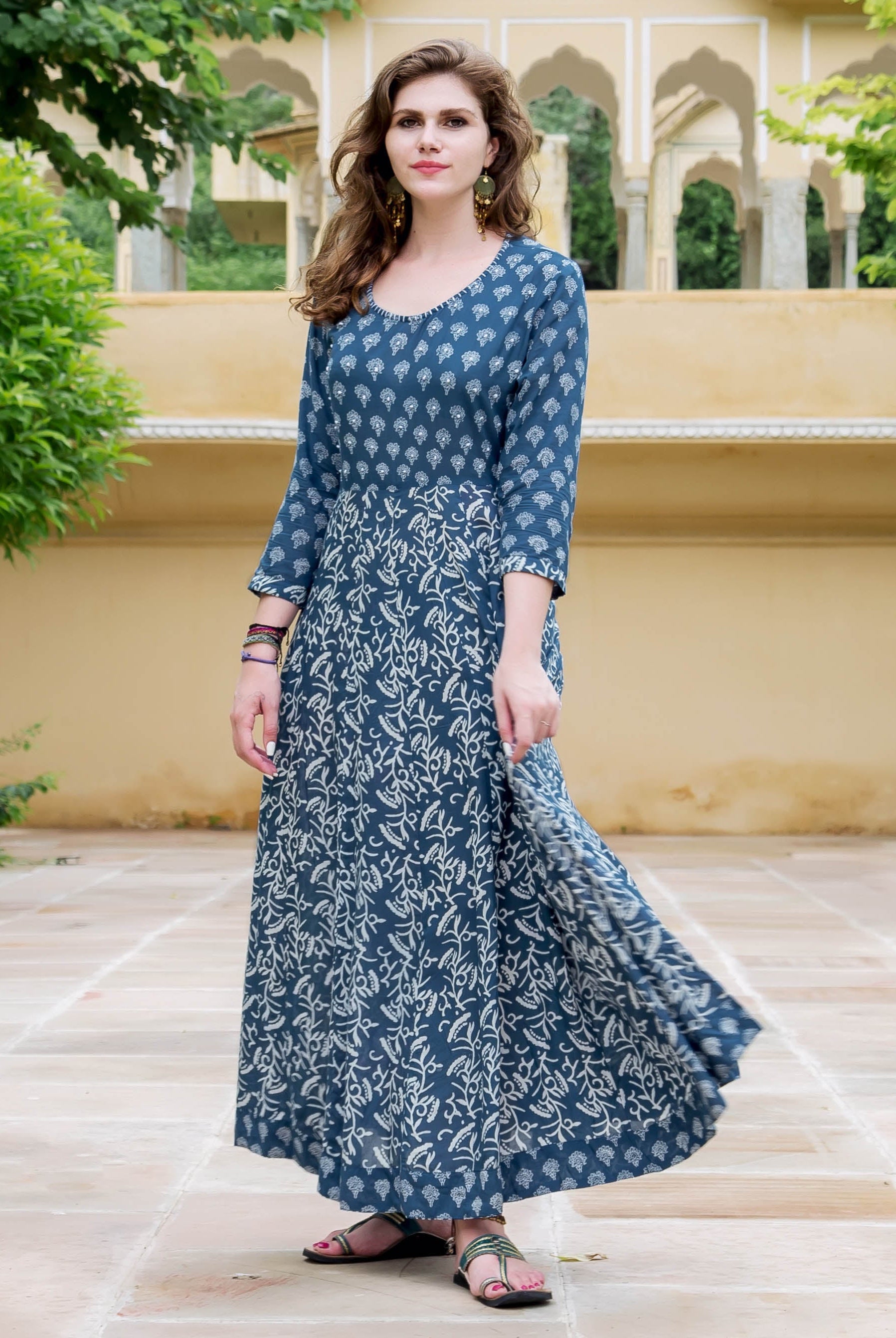 Woman models an indigo blue flared dress featuring two distinct white block print patterns.