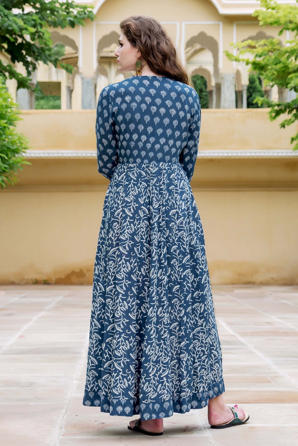 Back view of model in full indigo hand-block-printed flared dress with distinct patterns.