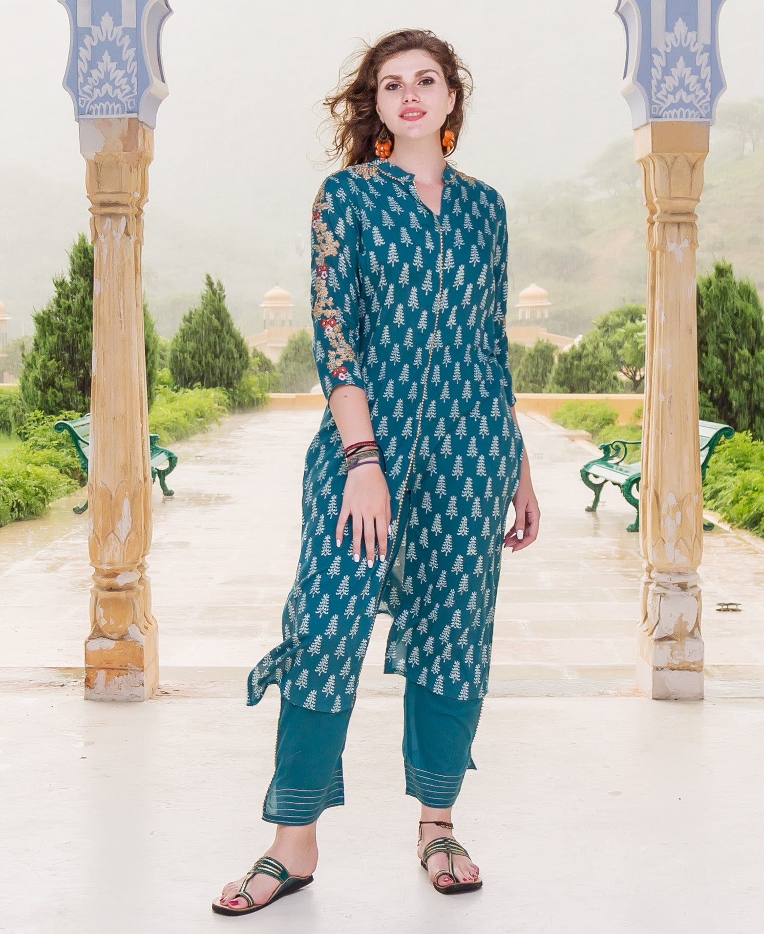 A model wearing a teal kurta with white tree print and embroidered sleeves.