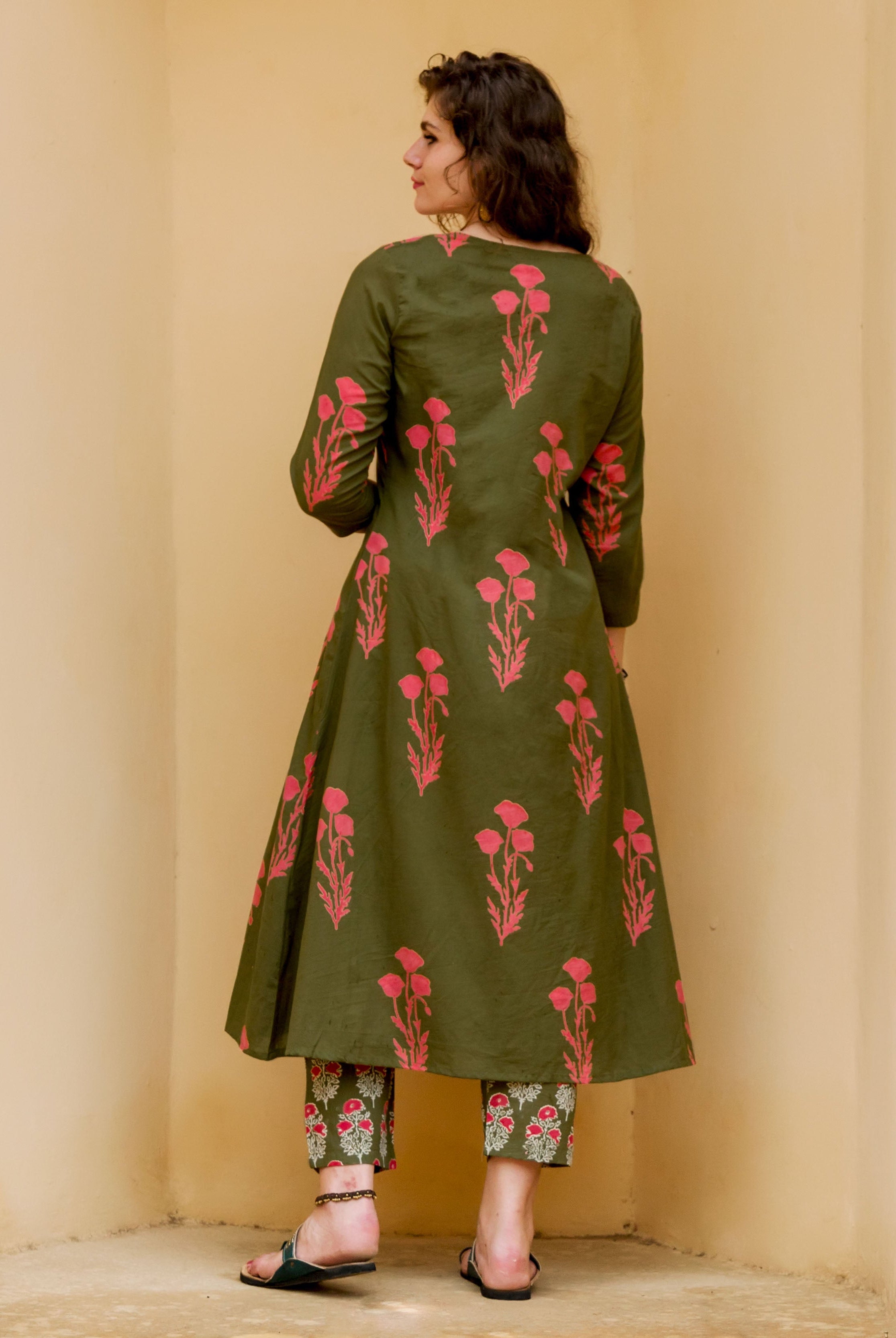 Back view of woman wearing olive green hand-block-printed kurta set with pink florals.