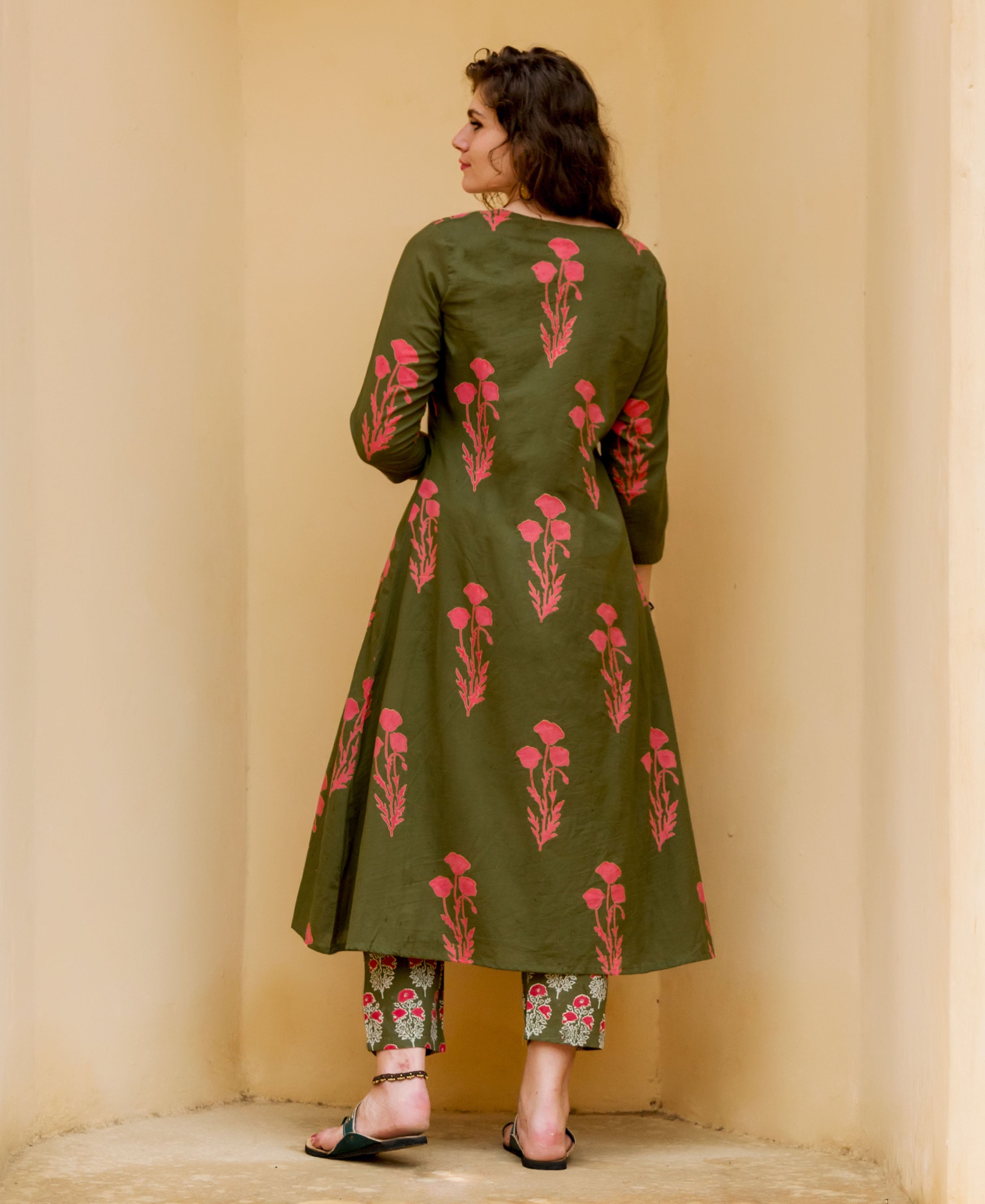 Back view of woman wearing olive green hand-block-printed kurta set with pink florals.