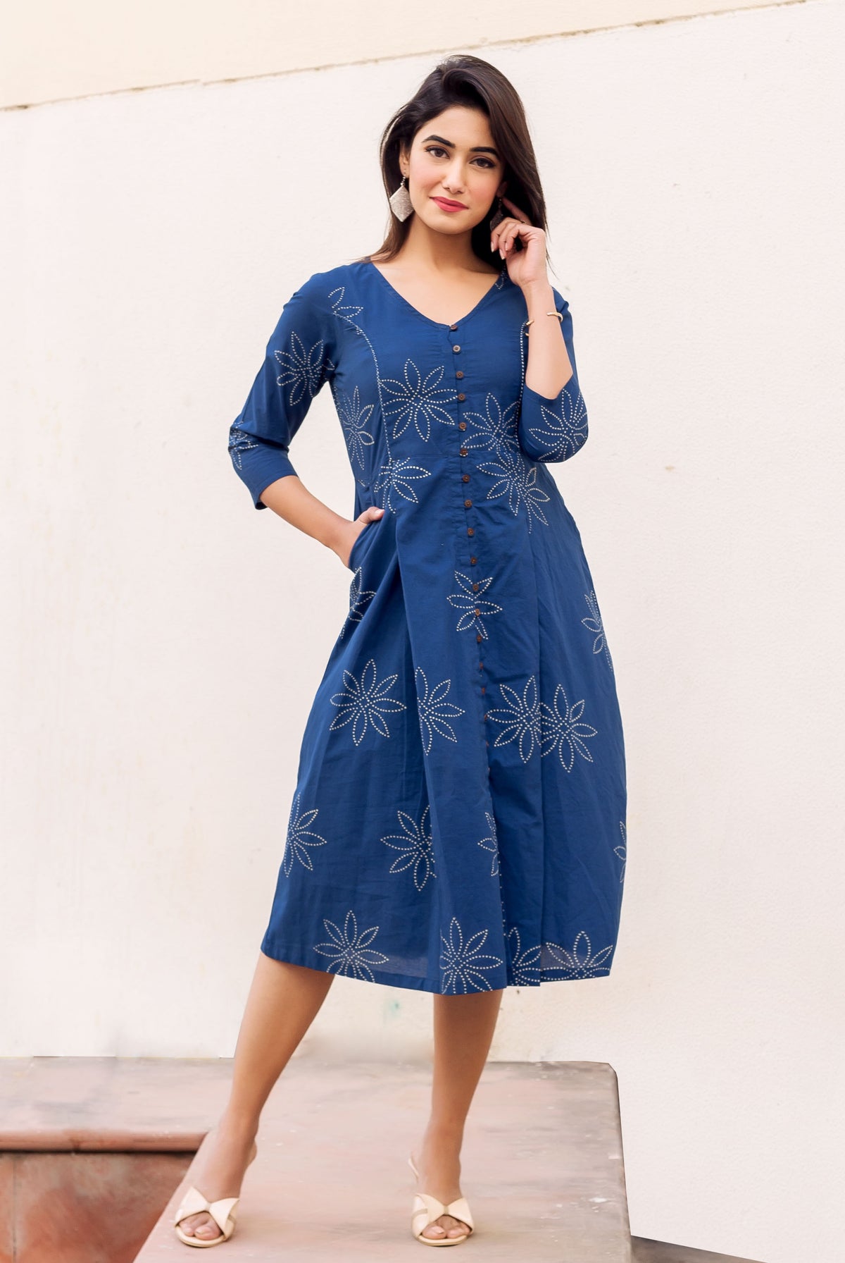 Front view of model in indigo blue button-down midi dress with white dotted floral print.