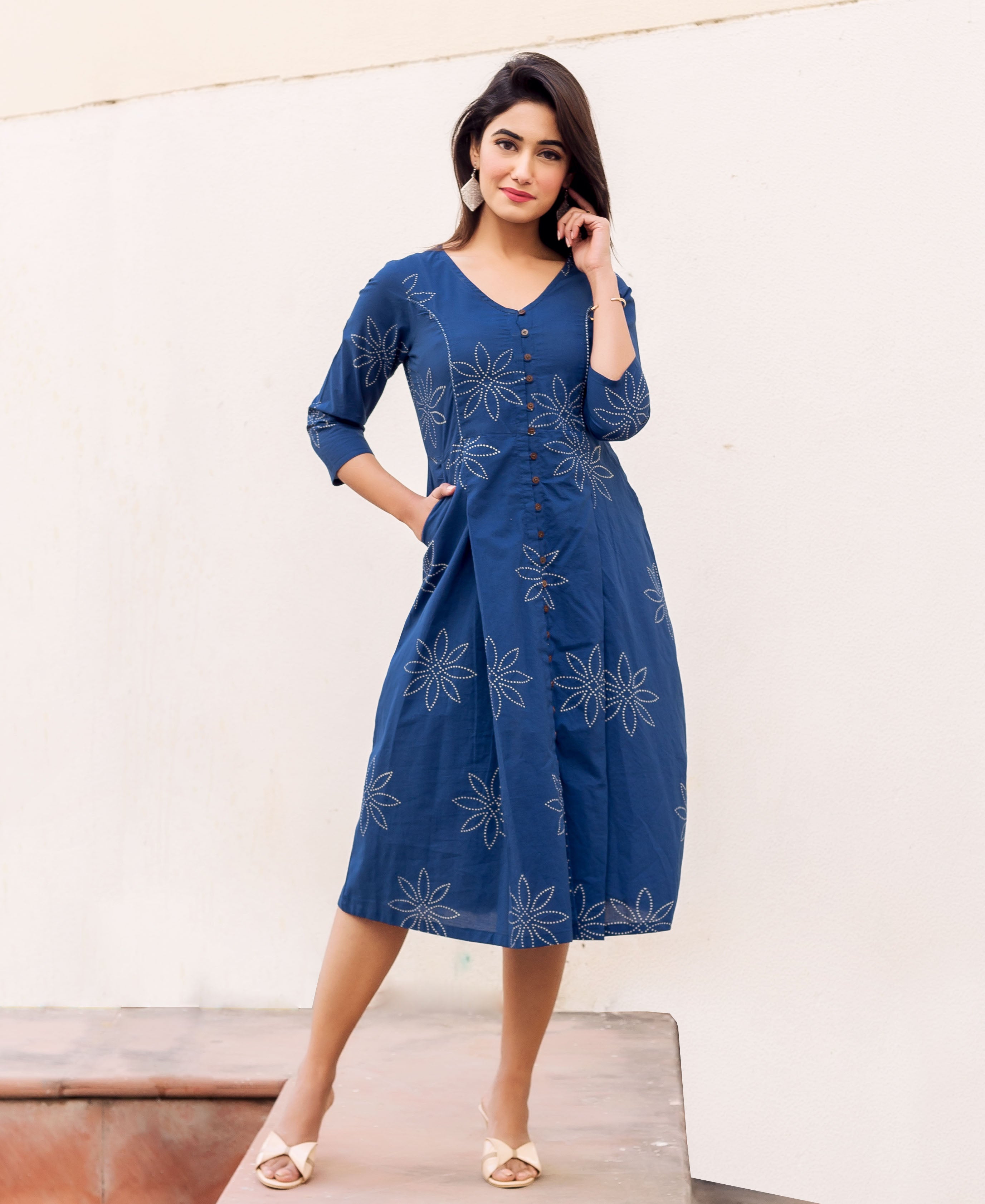 Front view of model in indigo blue button-down midi dress with white dotted floral print.