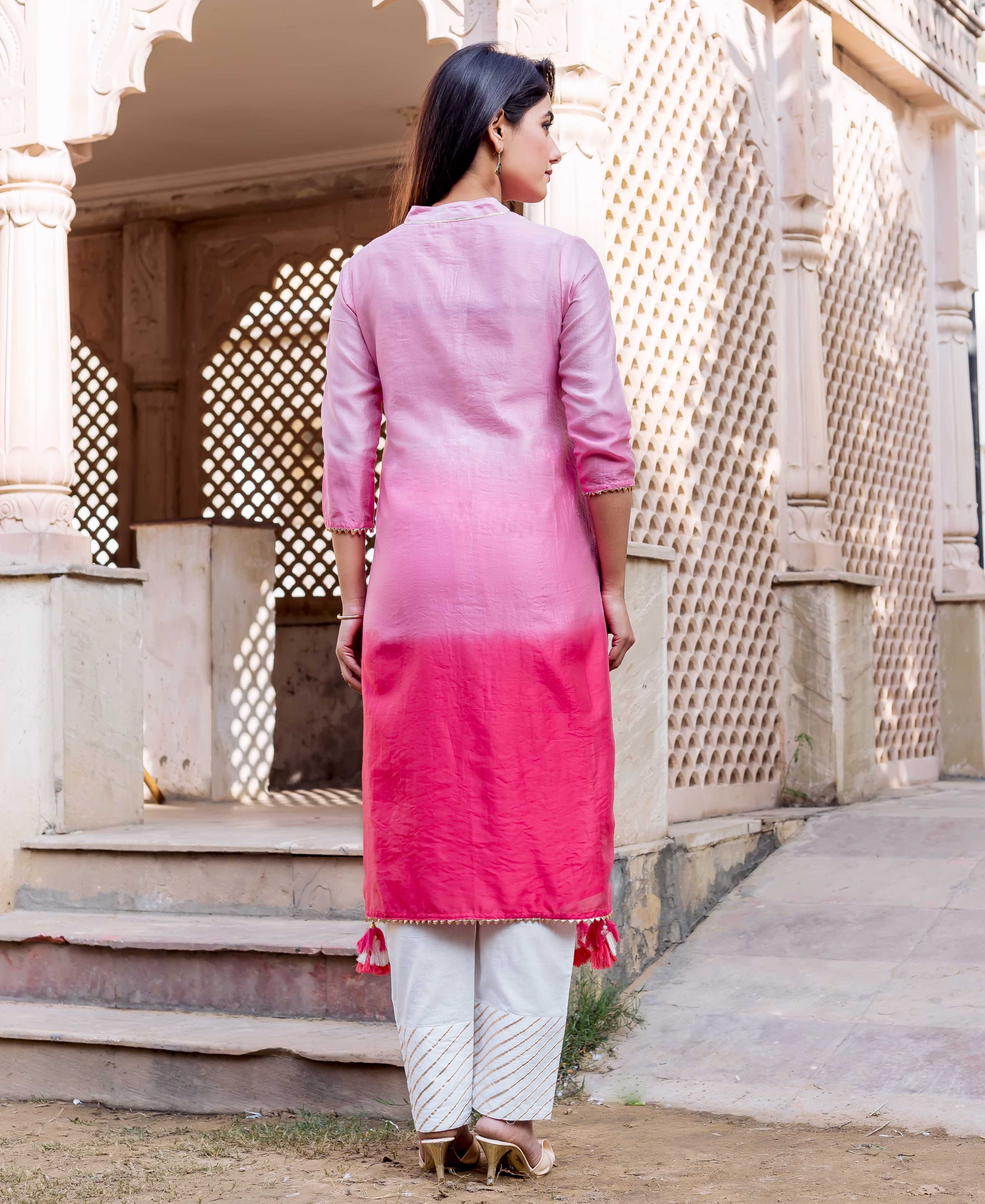 Back view of model in ombre pink kurta and white hand-block printed gold stripe pants.