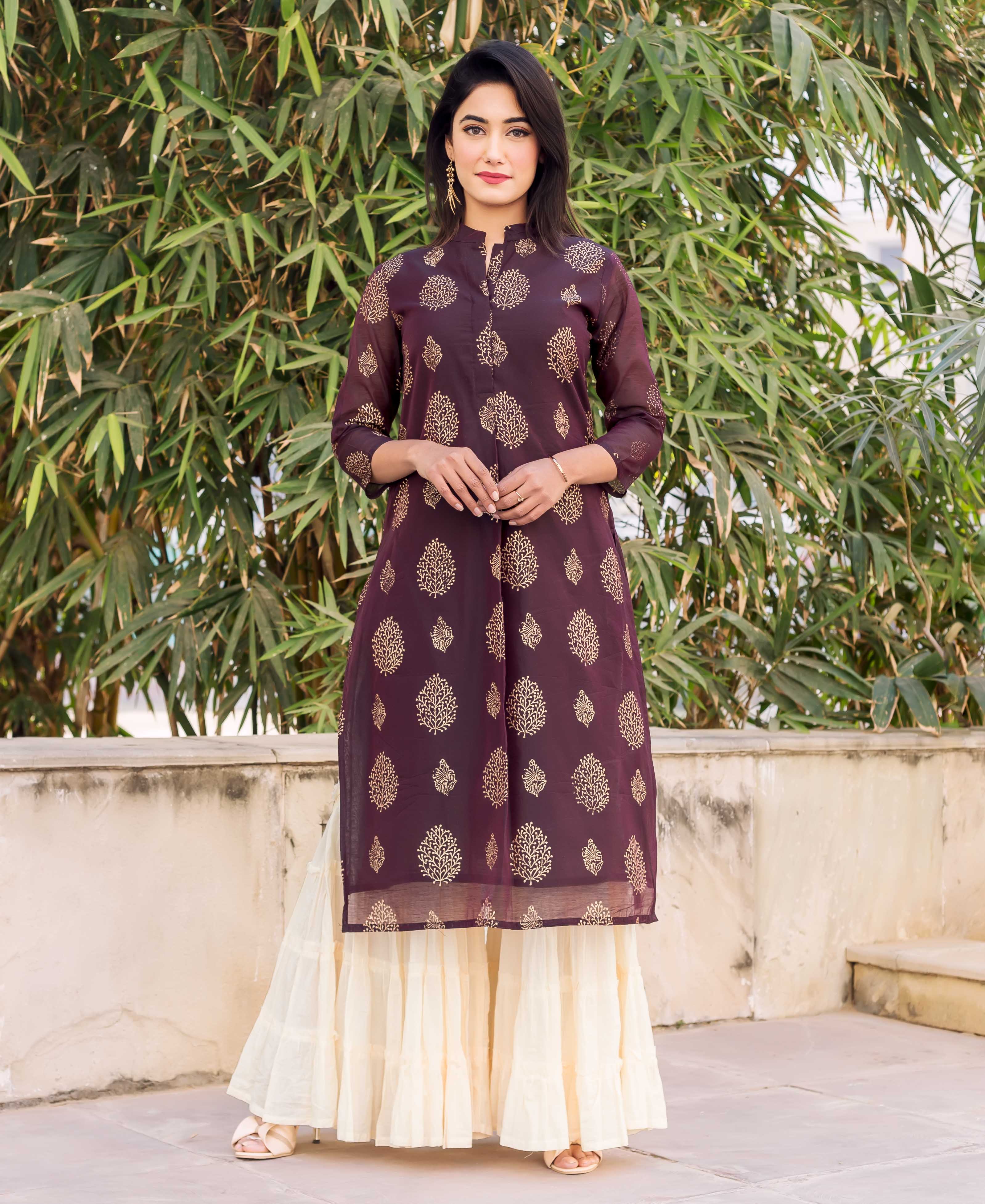 Model wearing wine gold block print kurti and creme tiered sharara.