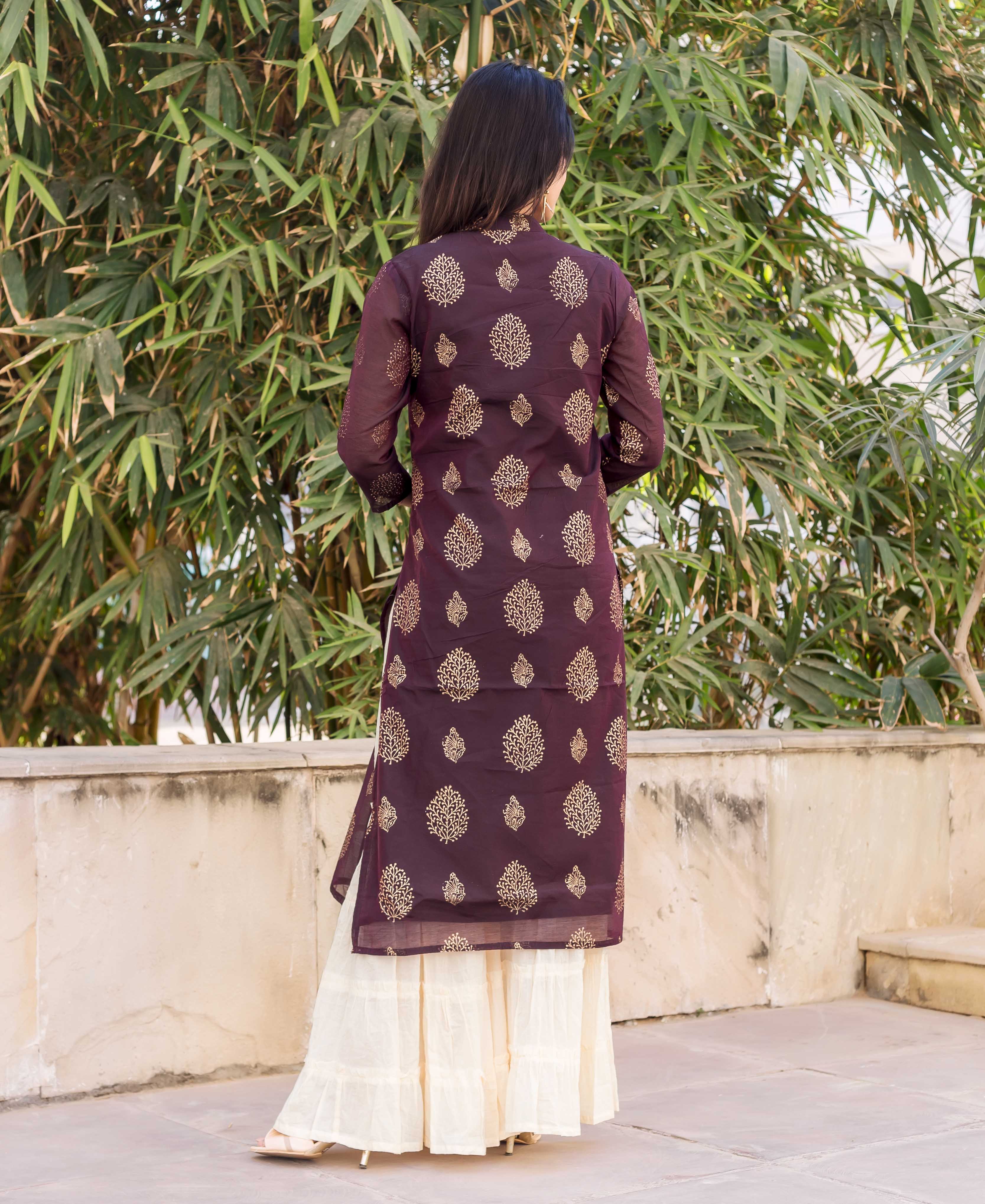 Back view of a model wearing a wine kurta with gold print and cream sharara.