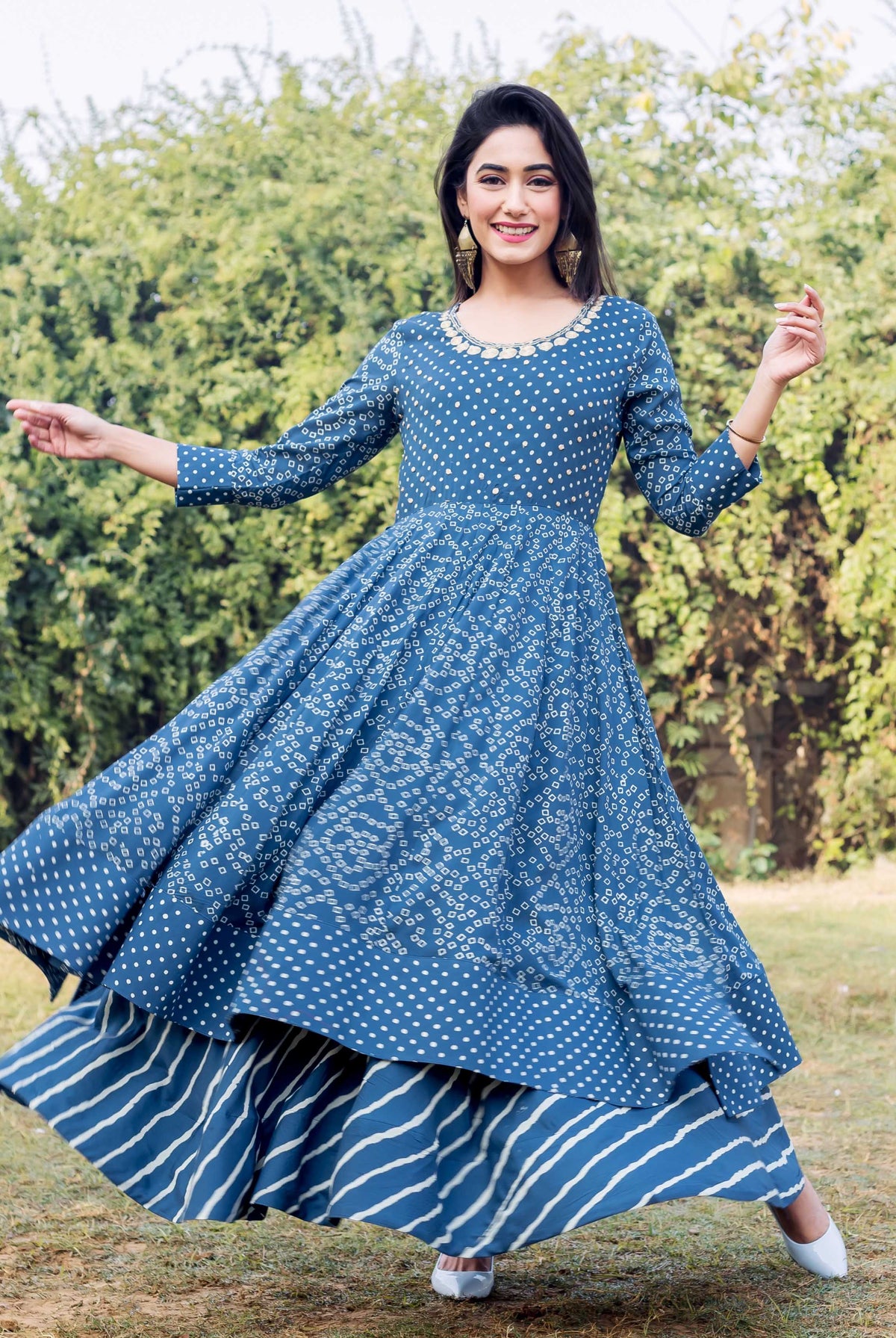 A model in a blue and white printed layered dress with embroidery.