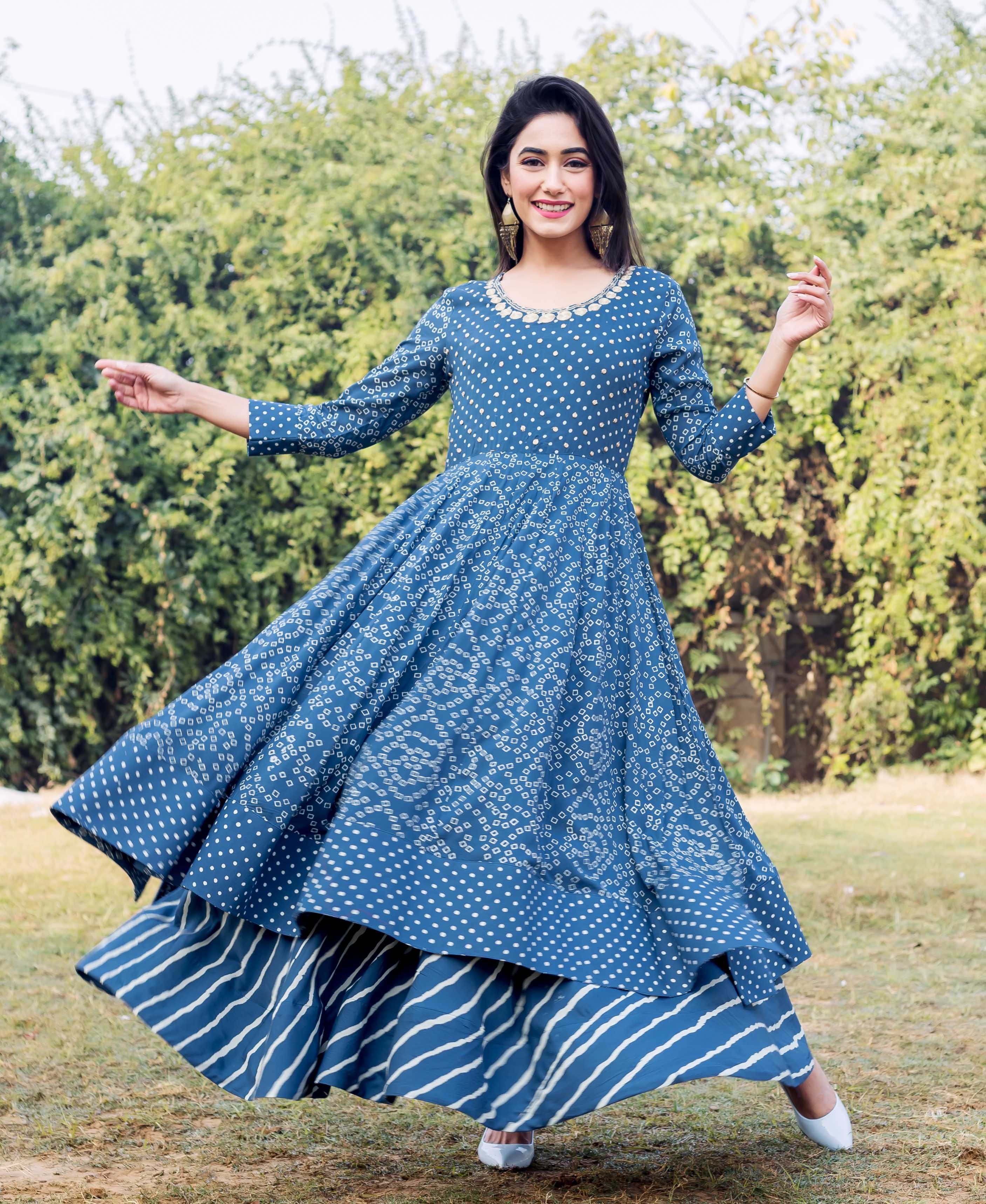 A model in a blue and white printed layered dress with embroidery.