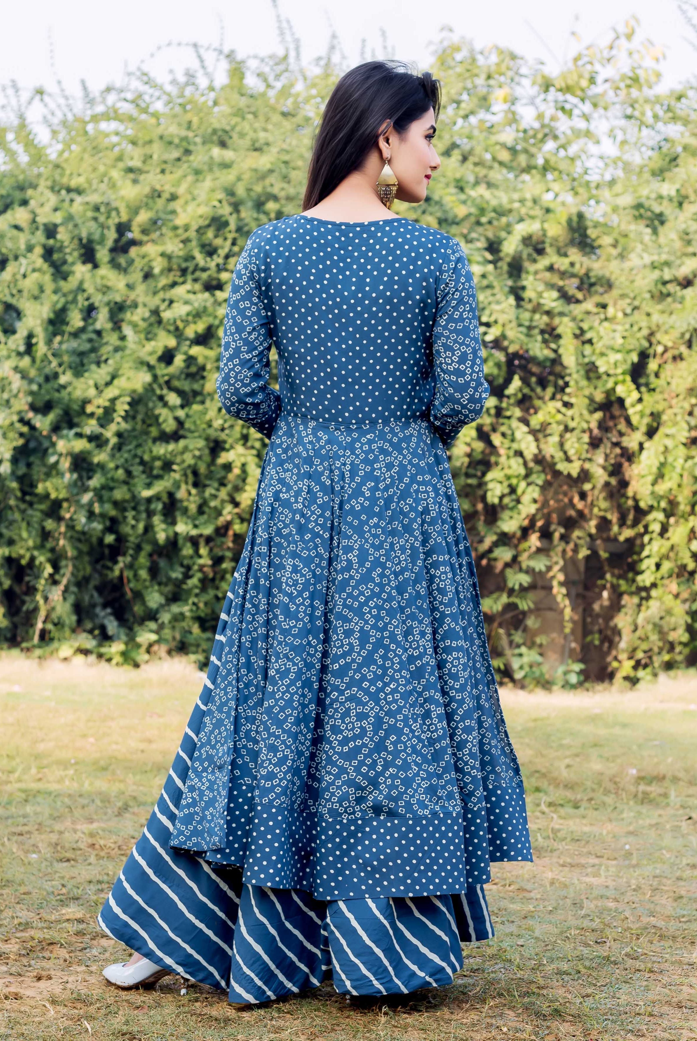 Back view of woman in layered indigo and white printed dress with matching striped bottoms.