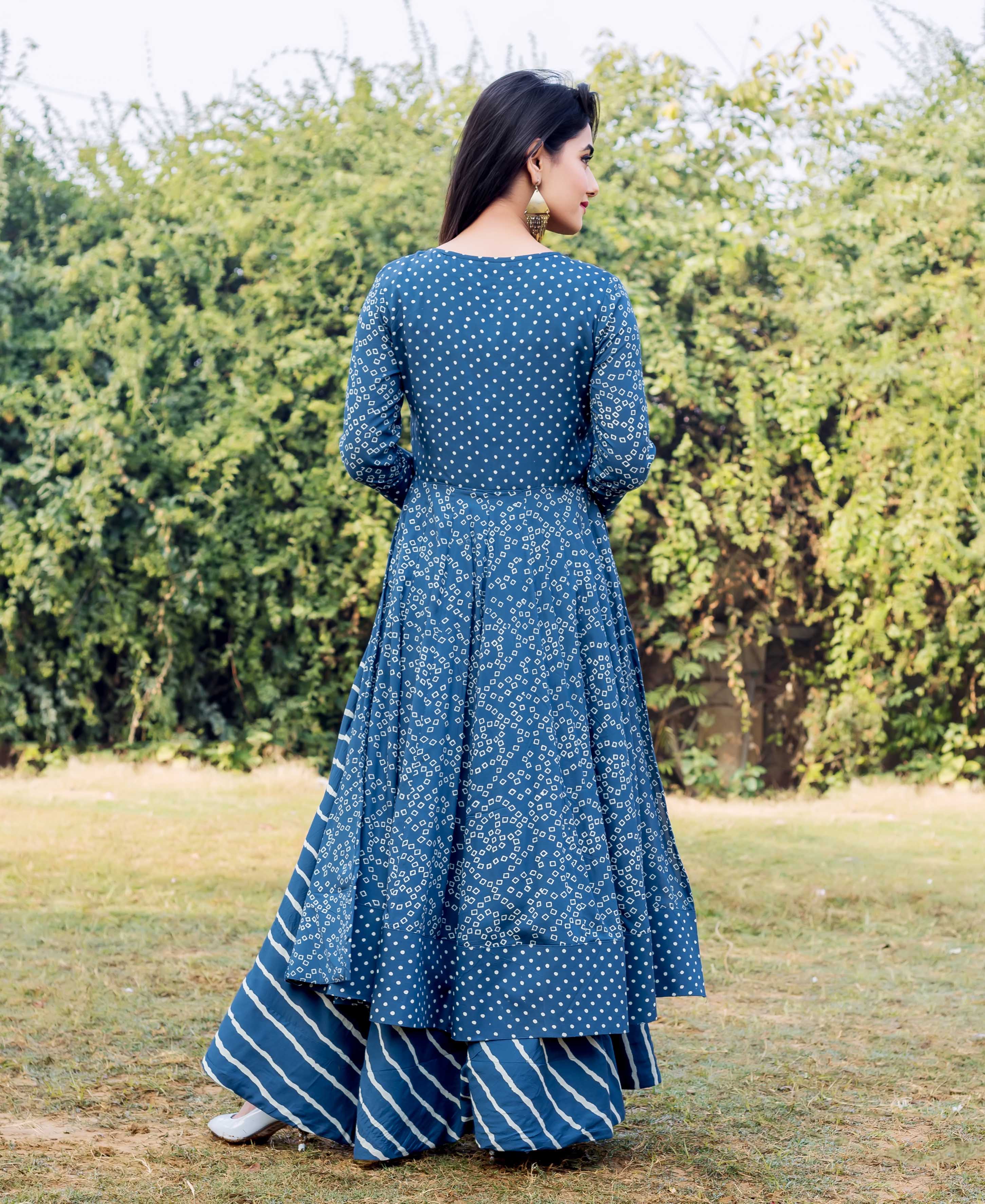 Back view of woman in layered indigo and white printed dress with matching striped bottoms.