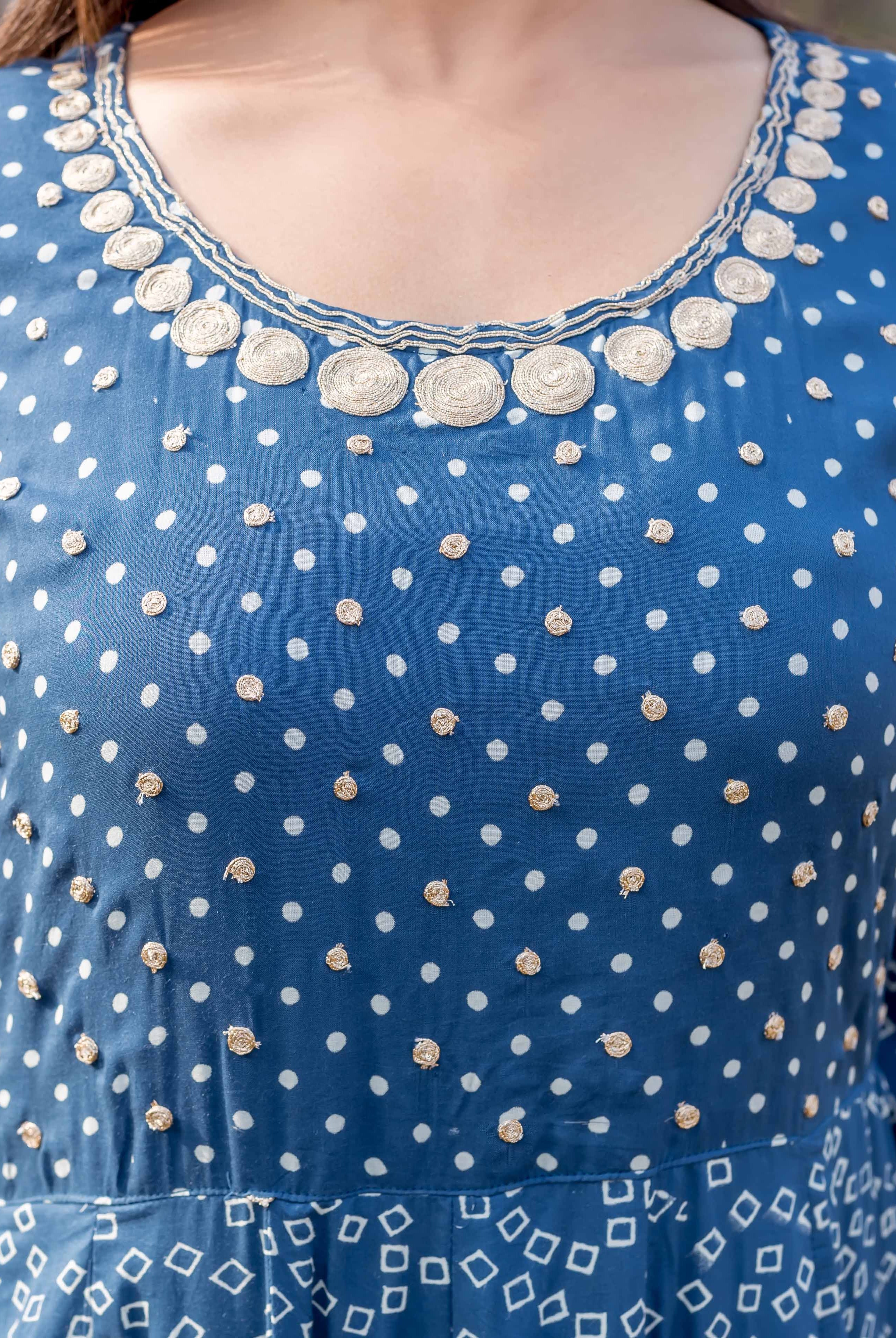 Front close-up of indigo blue dress with white patterns and golden embroidered yoke.