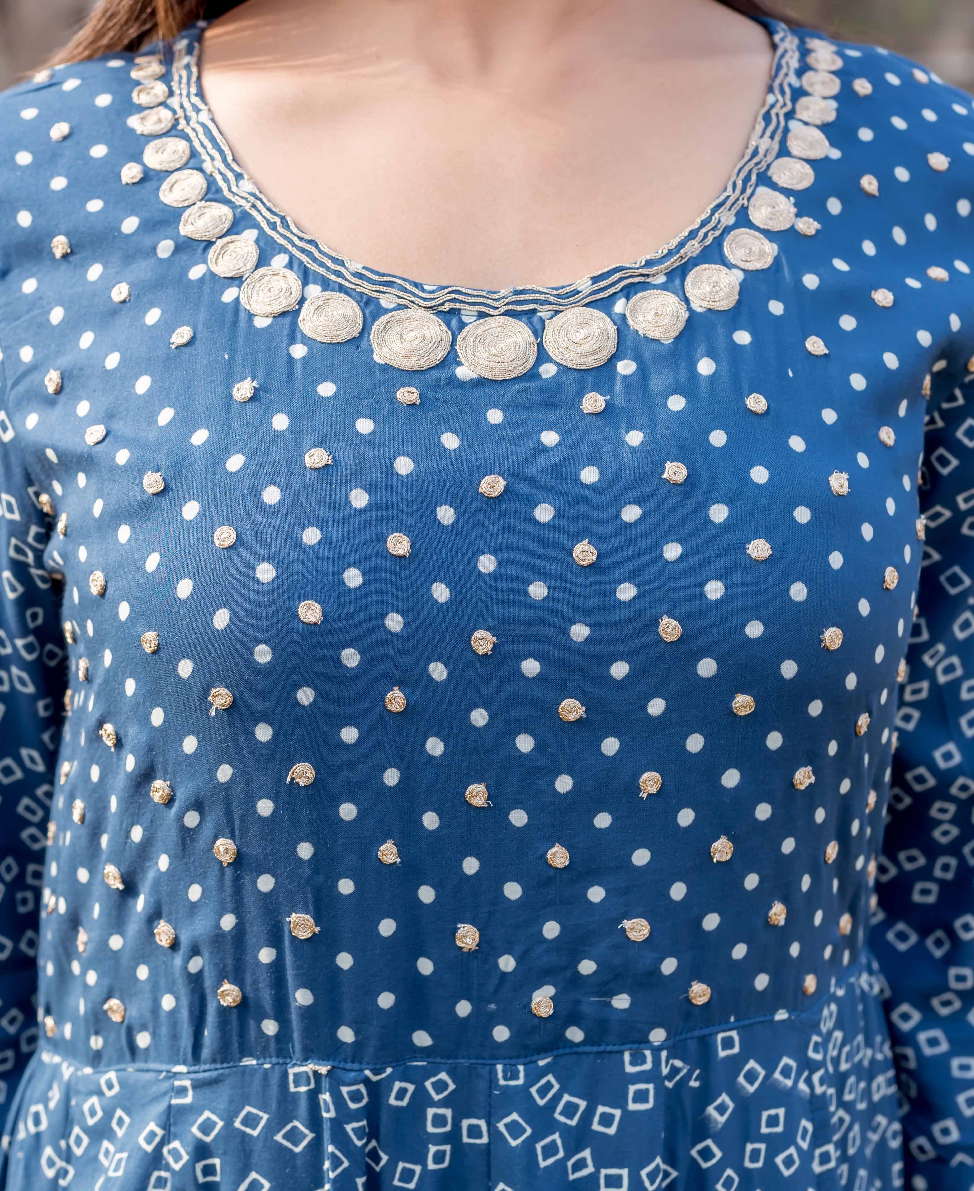Front close-up of indigo blue dress with white patterns and golden embroidered yoke.