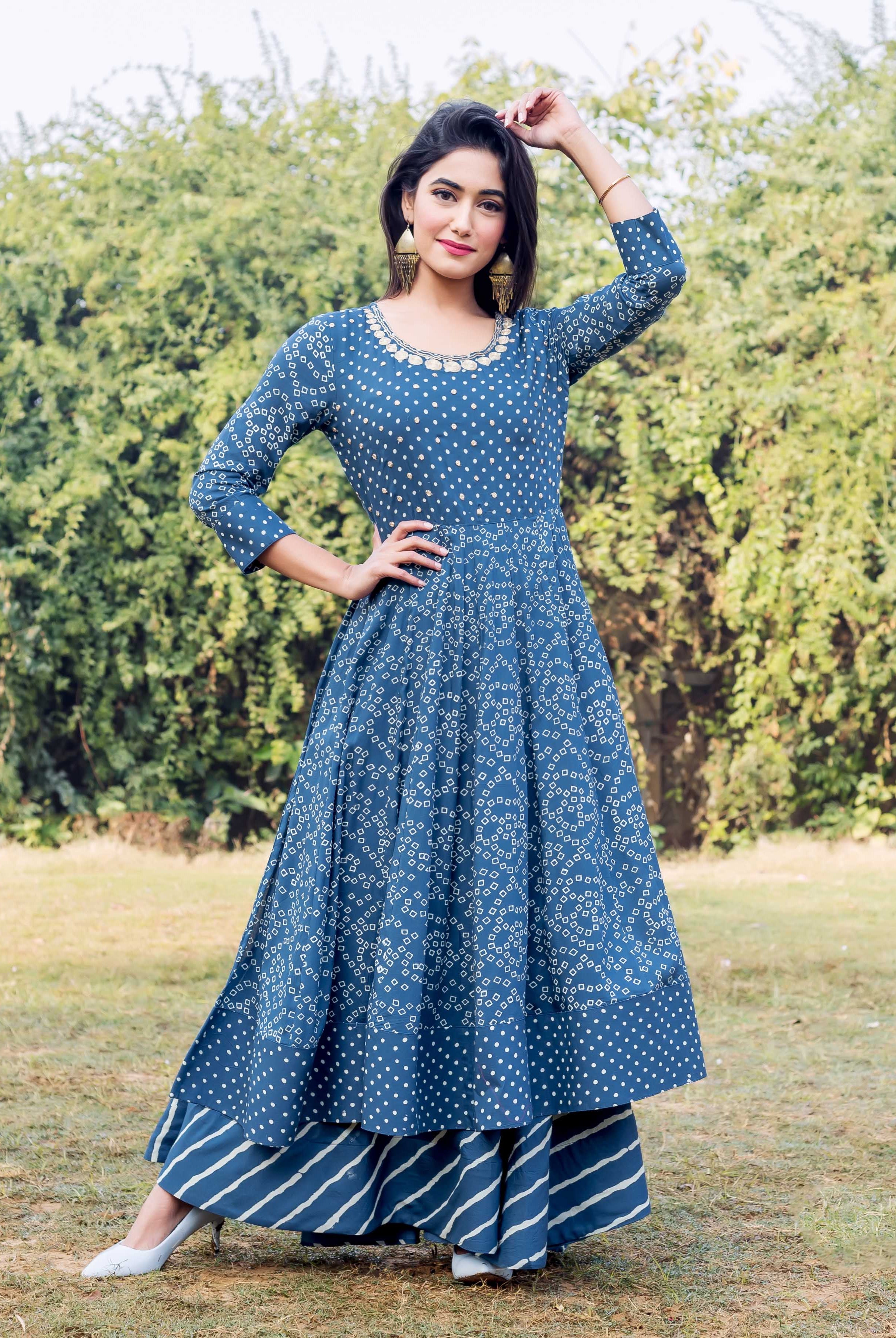 Front full-look of model in an indigo and white printed layered dress with embroidered neckline.