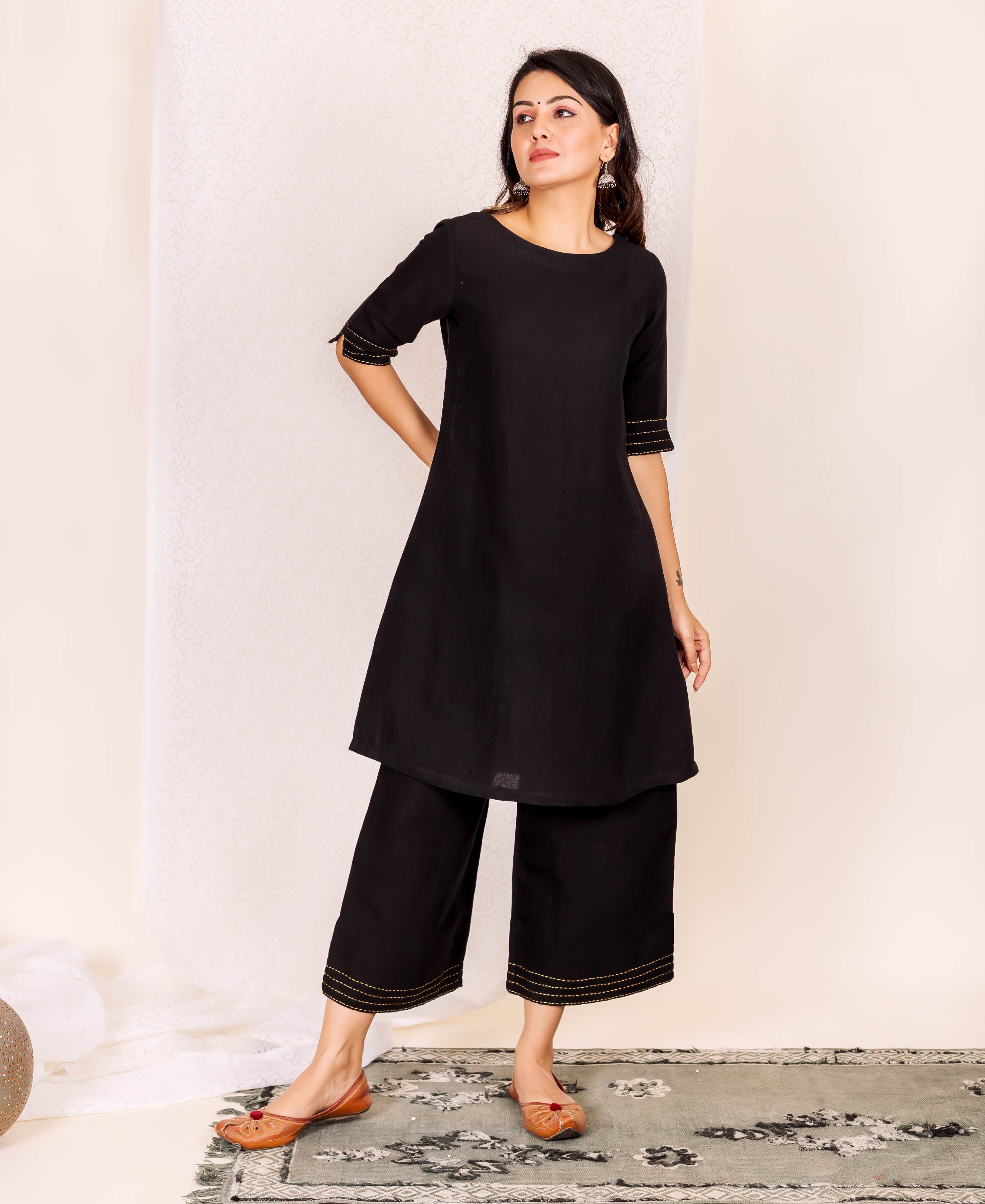 Full look, model in black linen ethnic kurta set with golden linear stitch.