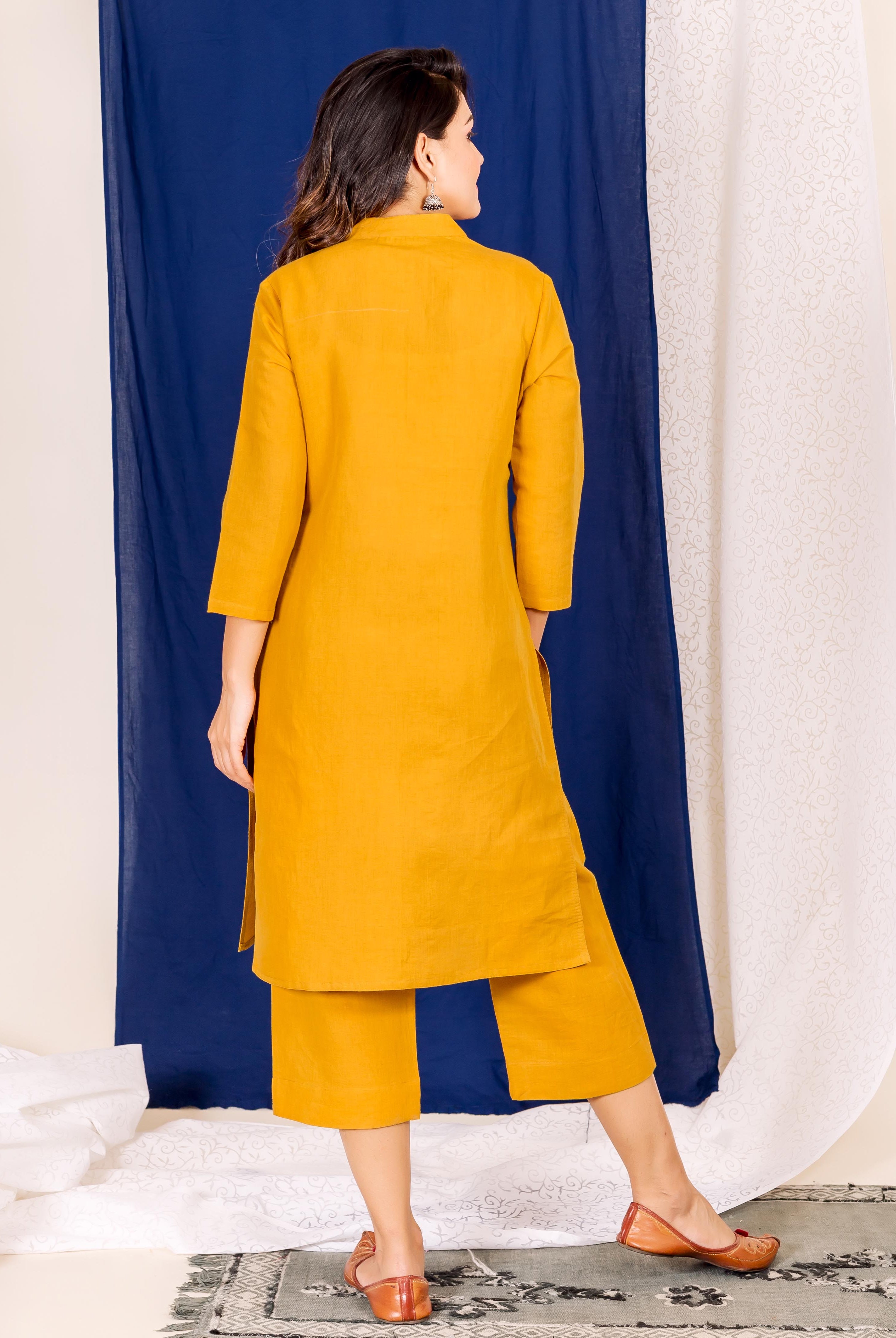 A model wearing a mustard linen kurta with a hand-block print design.