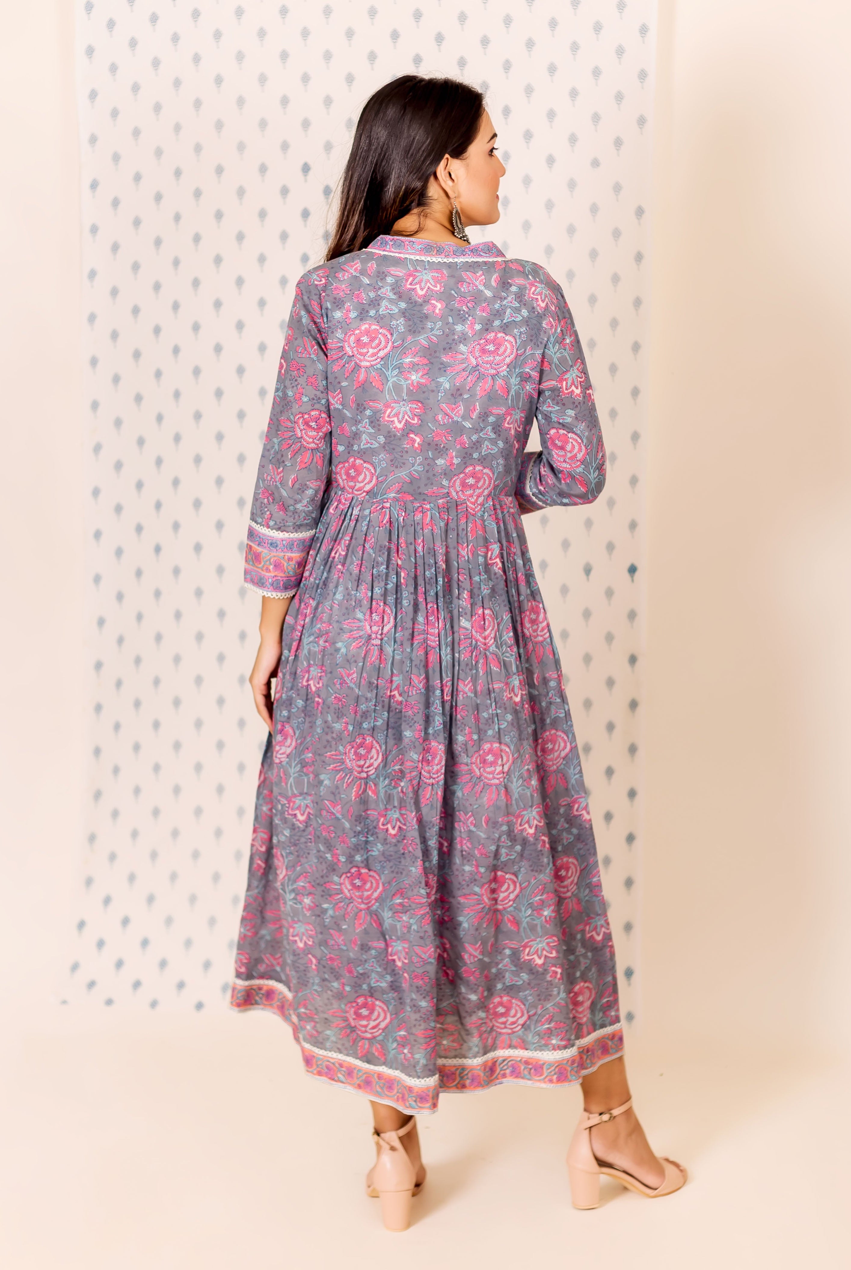 A model wearing a grey and pink hand block printed dress with an inner lining.