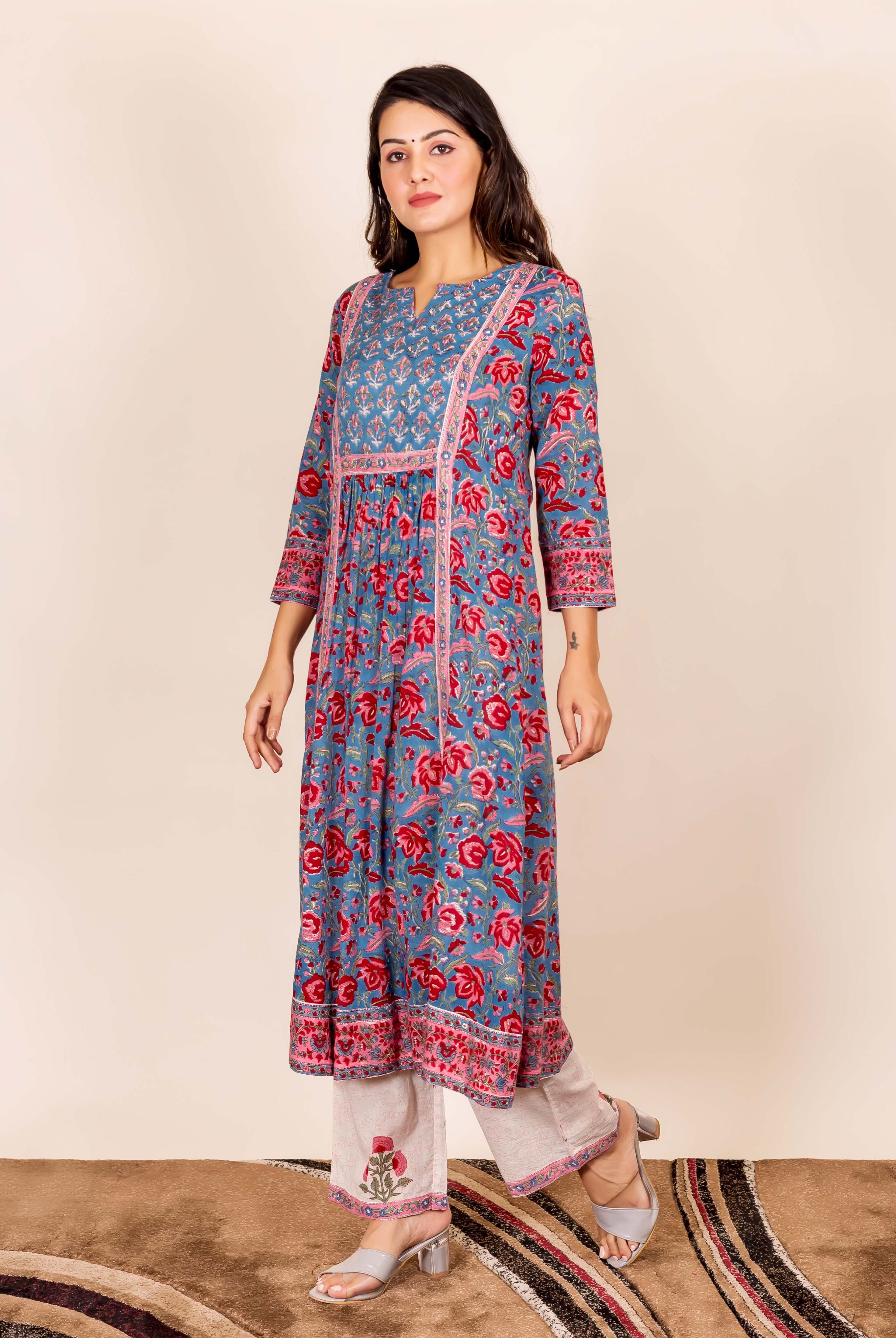 Model wearing a blue and red floral hand block printed kurta with beige pants.
