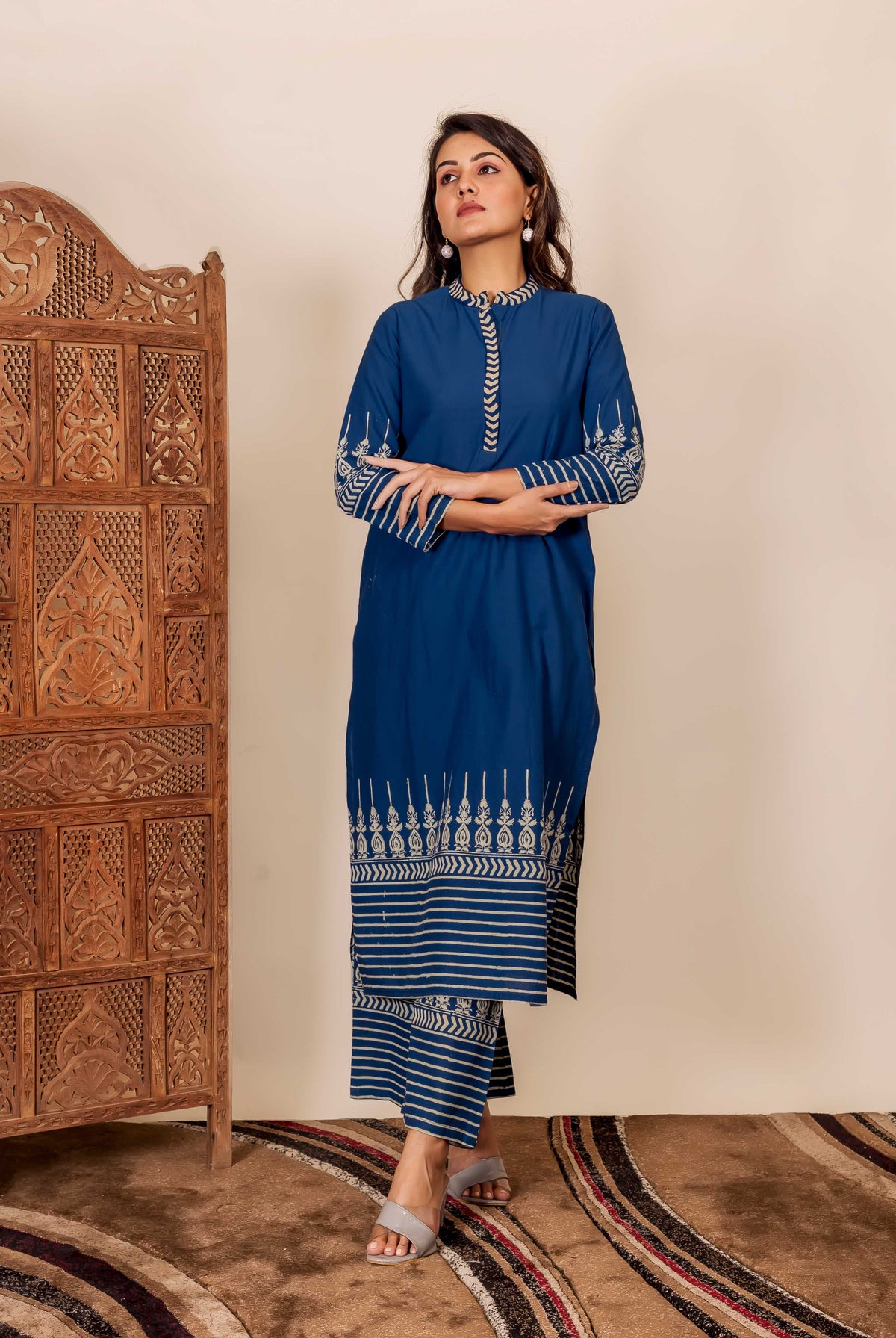 Model wears indigo hand-block printed kurta and pants with white ethnic patterns and stripes.