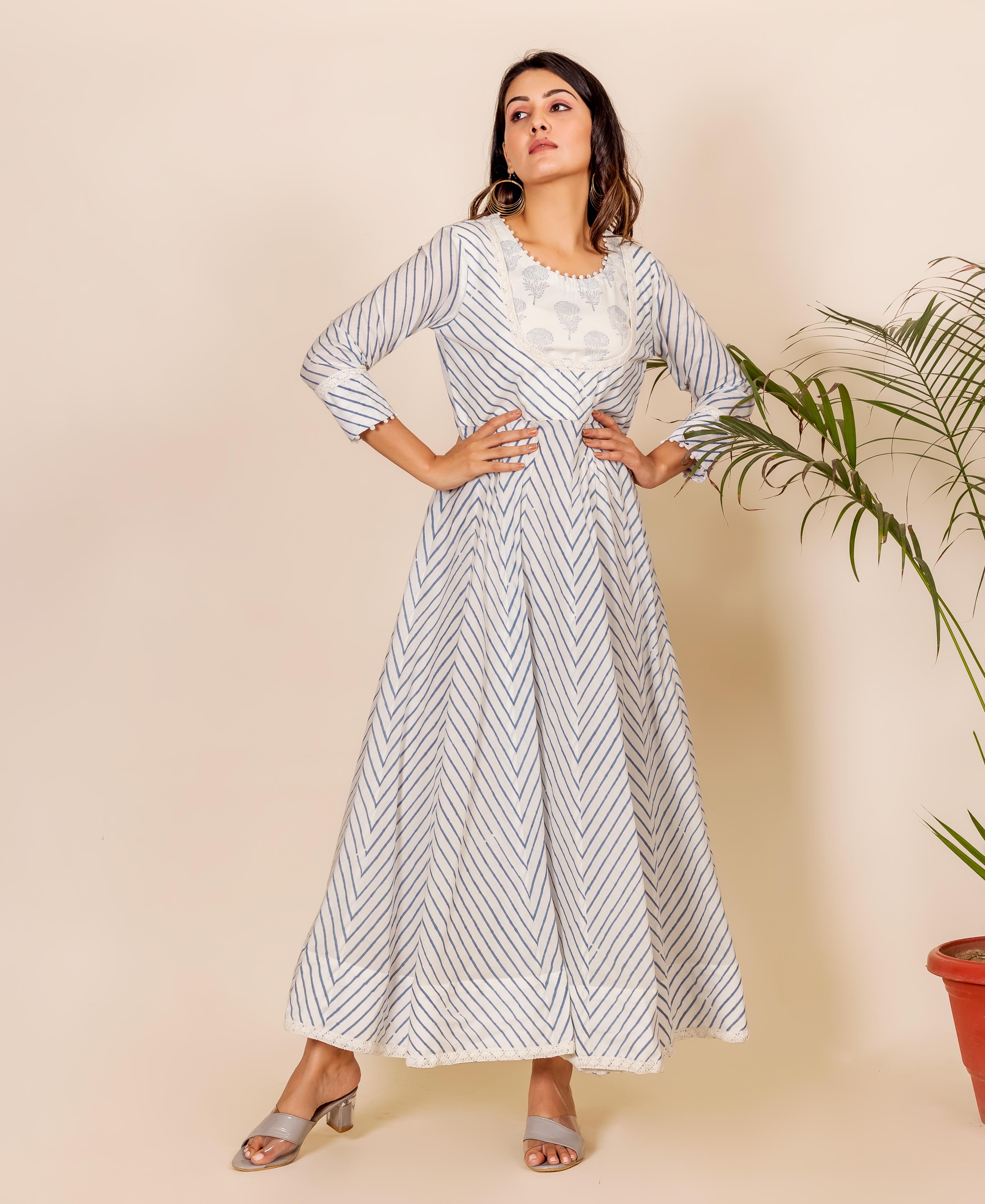 Full-length model wears a white Anarkali dress with blue zig-zag print and embroidered yoke.